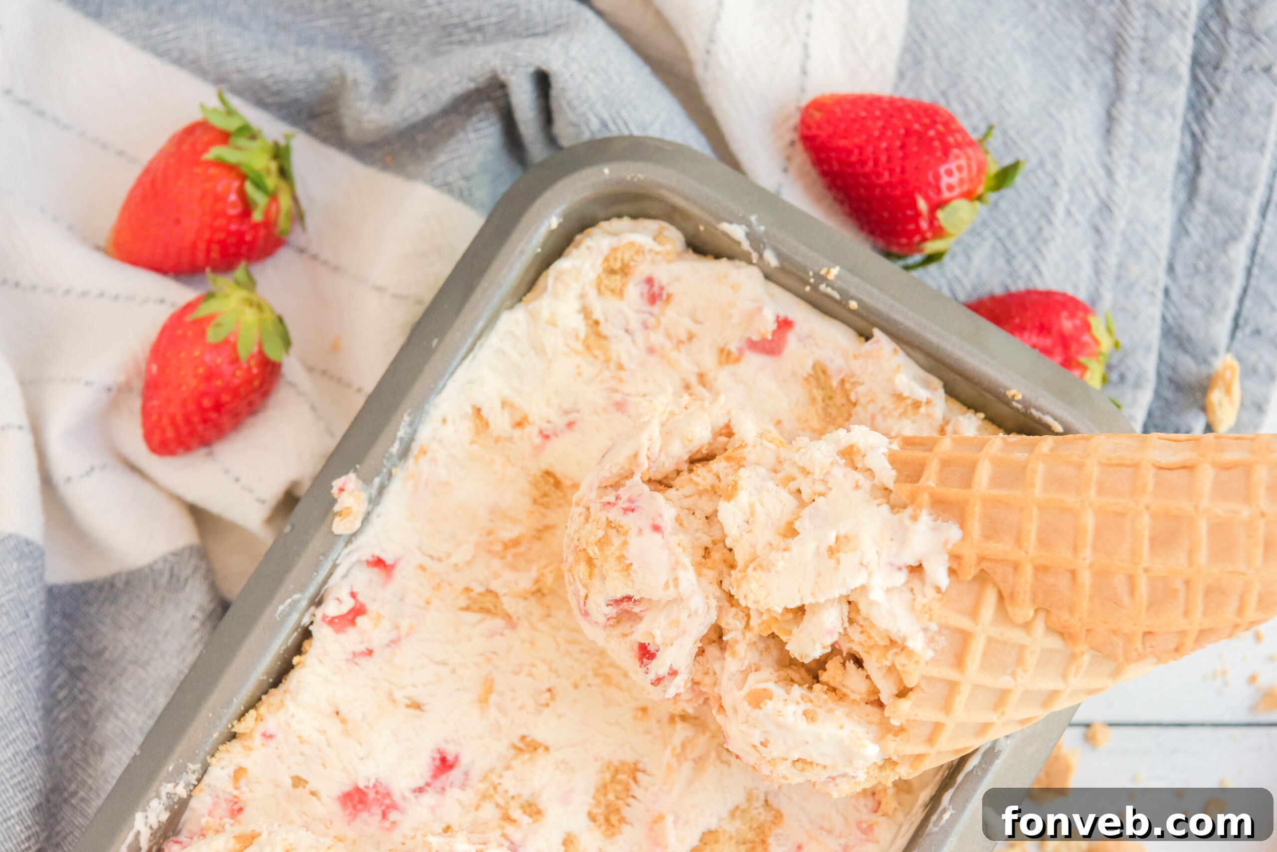 Frozen Strawberry Cheesecake Dream 4 Strawberry Cheesecake Ice Cream with a cone dipping in it.