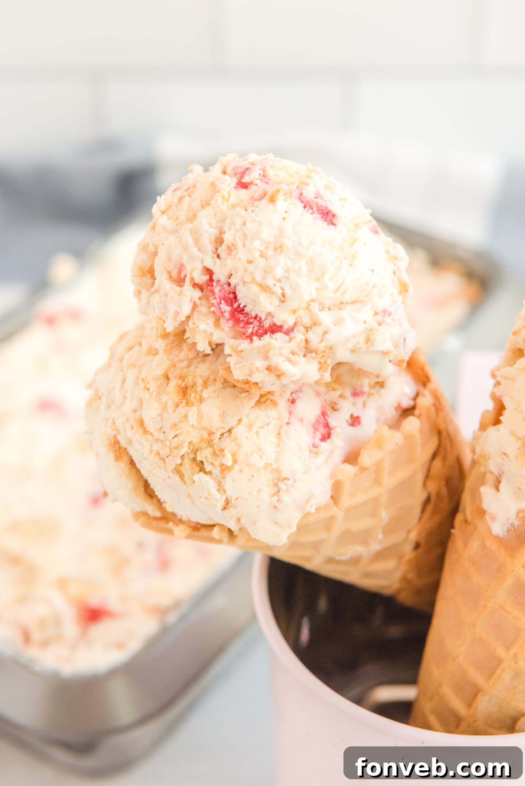 Frozen Strawberry Cheesecake Dream 7 Up close view of a waffle cone with a scoop of Strawberry Cheesecake Ice Cream.