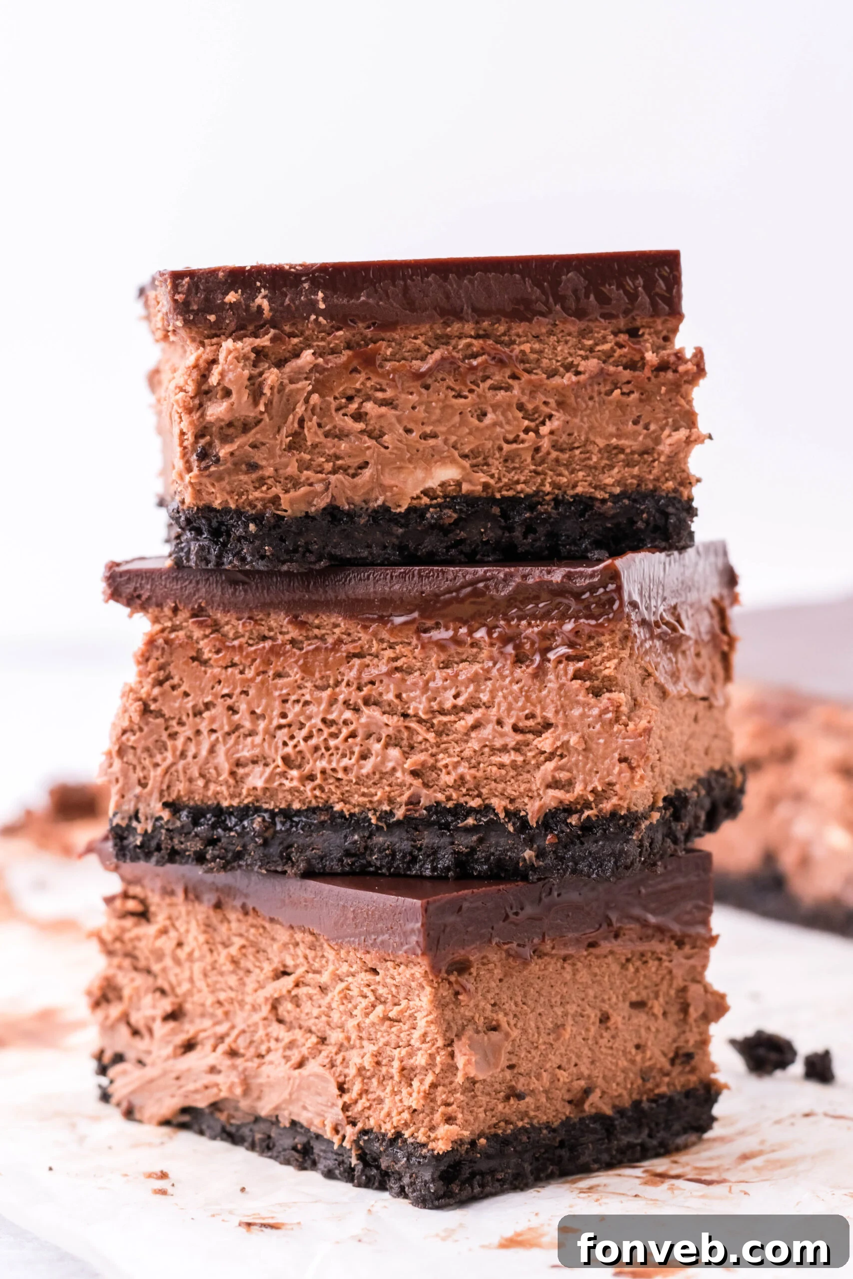 Three bars of chocolate cheesecake stacked on top of each other.