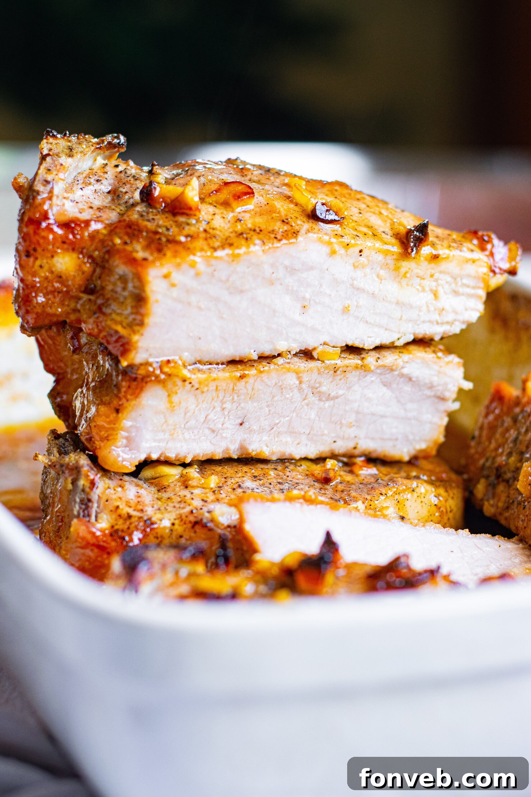 Front view of two halved Honey Garlic Pork Chops, stacked to show their juicy interior.