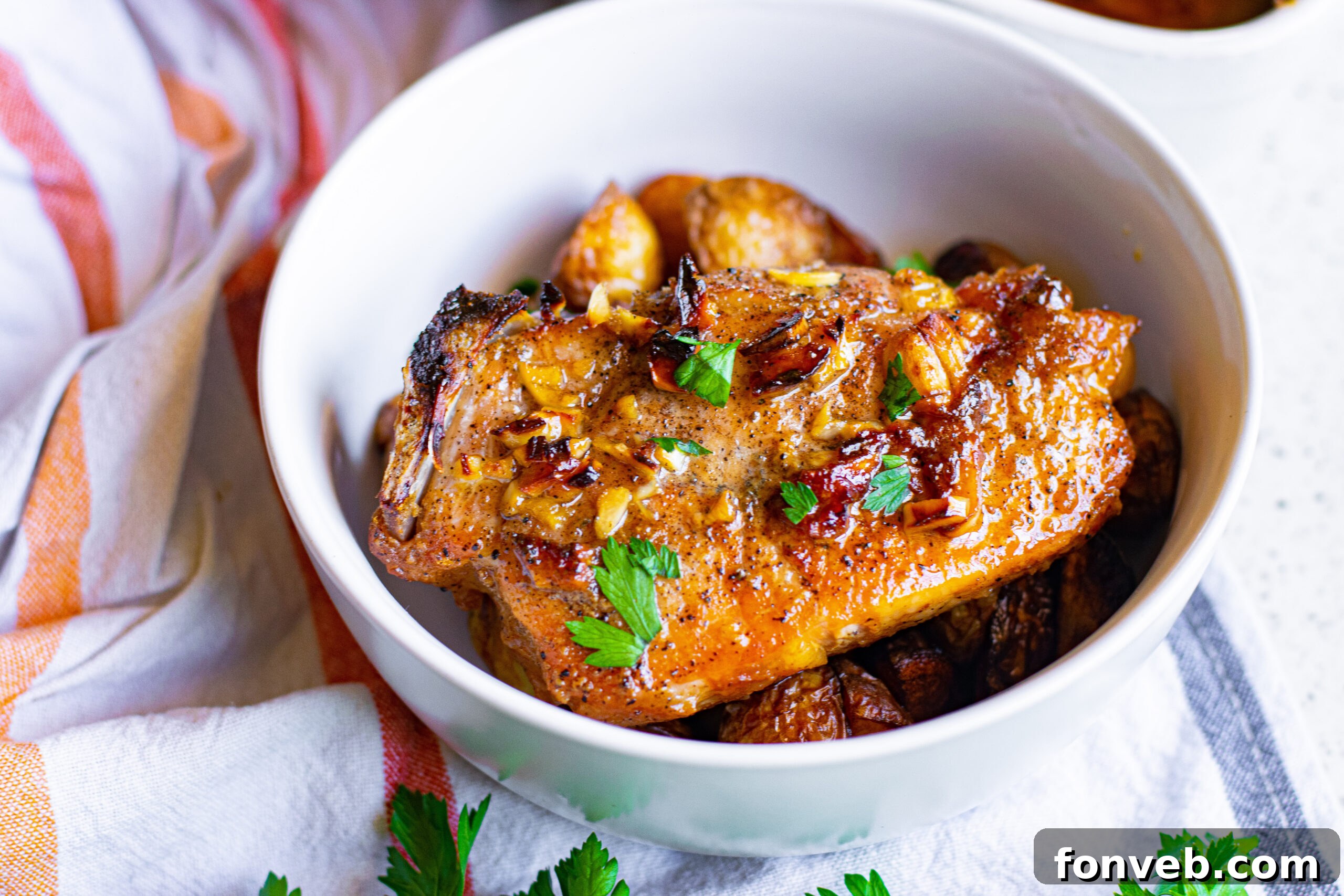 Overhead view of a serving of Honey Garlic Pork Chops with roasted vegetables on a rustic wooden table.