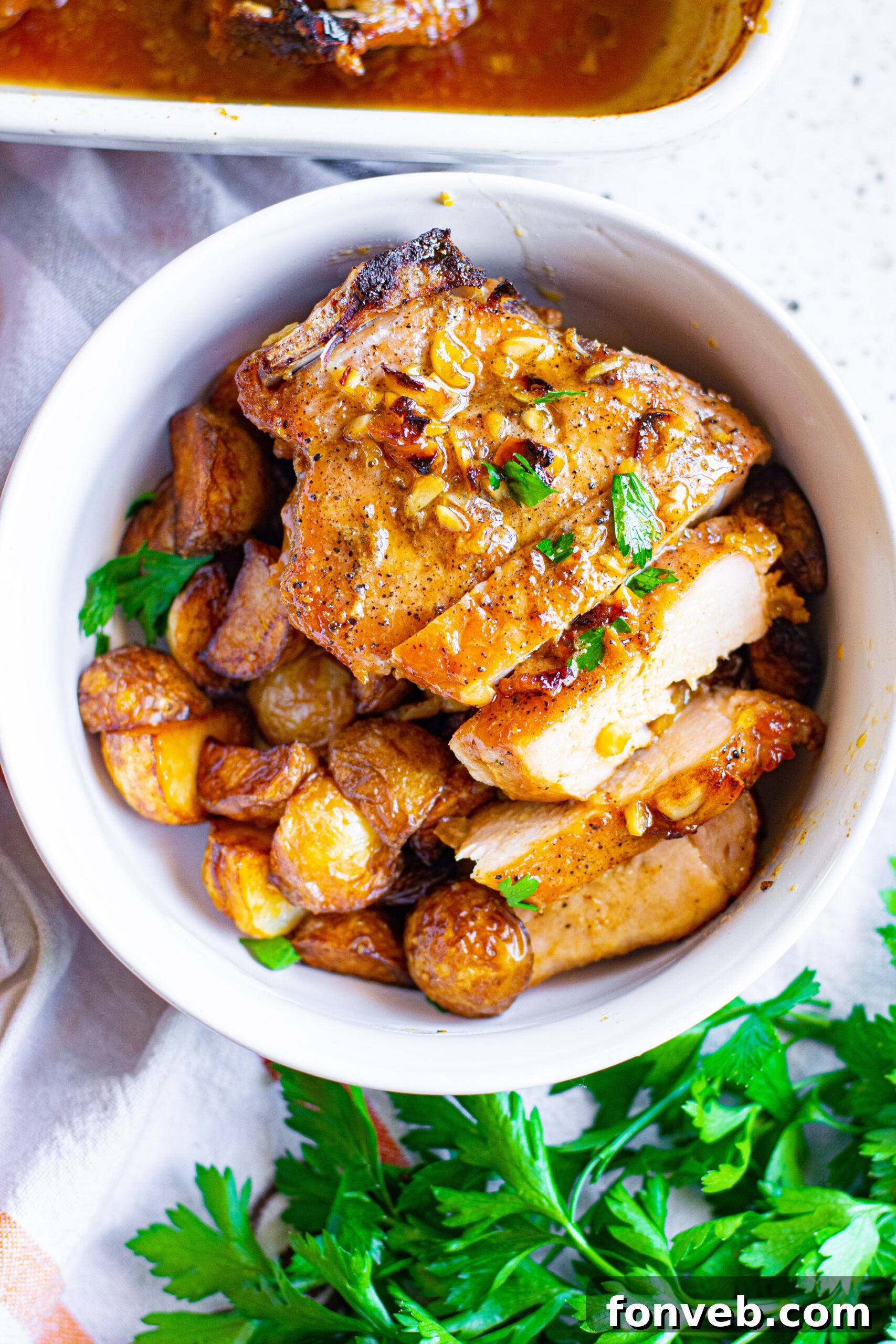 Overhead view of Honey Garlic Pork Chops sliced into strips and served over mashed potatoes, garnished with herbs.