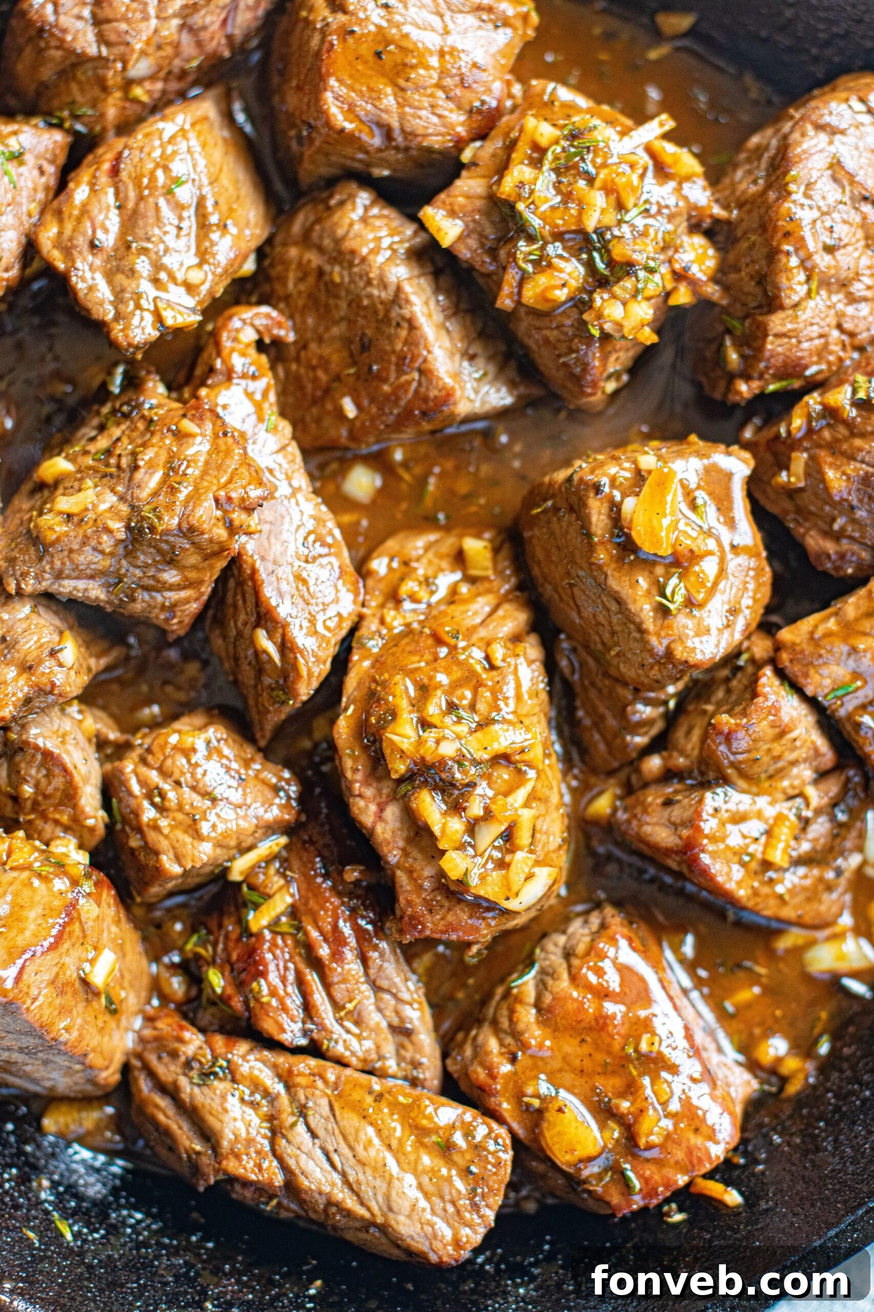 Up close view of Garlic Honey Steak Bites in a cast iron skillet.