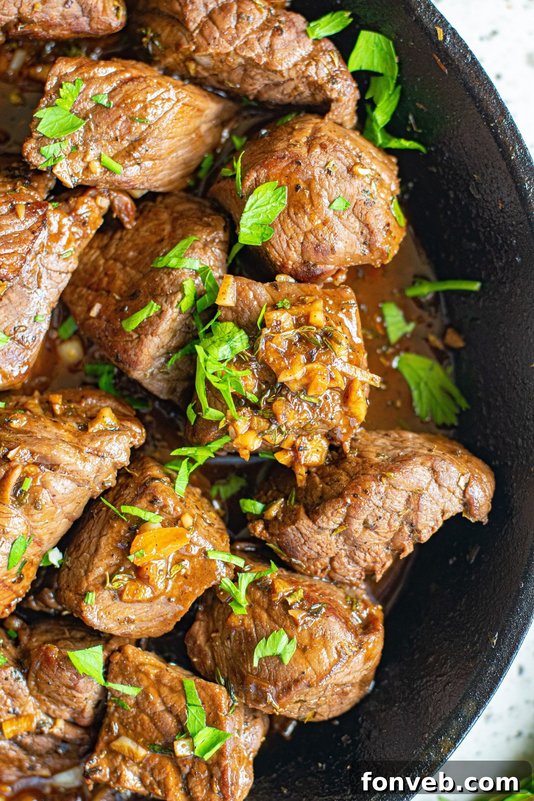 Close up view of Garlic Honey Steak Bites in a cast iron skillet.
