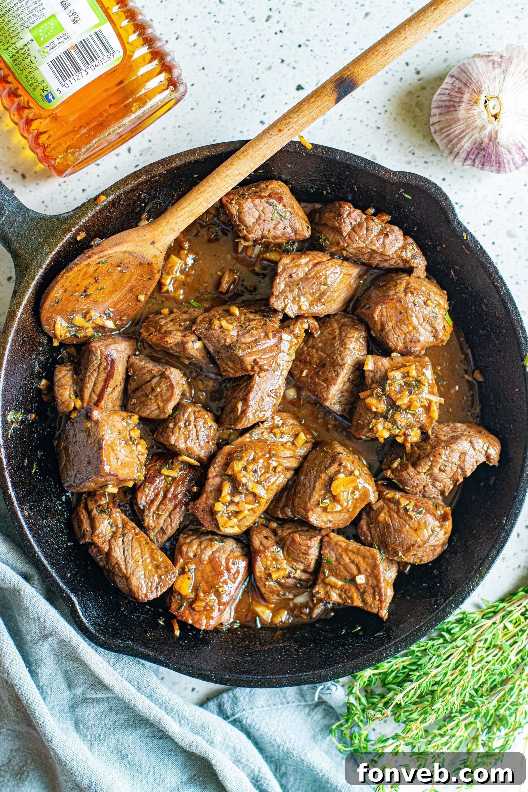Overhead view of Garlic Honey Steak Bites in a cast iron skillet. 