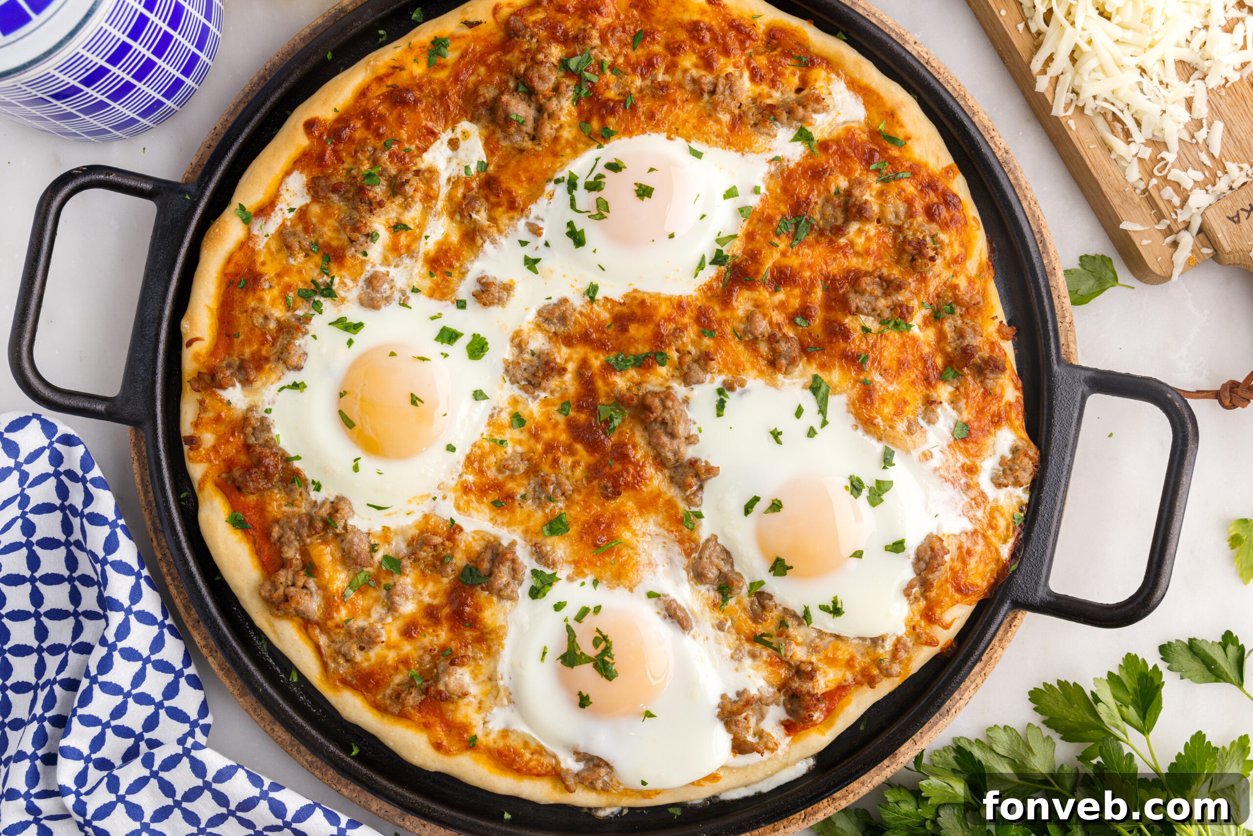 An appetizing close-up of a Breakfast Pizza on a black pizza pan, highlighting the perfectly cooked eggs and melted cheese.