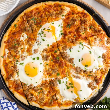 Overhead view of Breakfast Pizza on a black pizza dish cut into square slices.