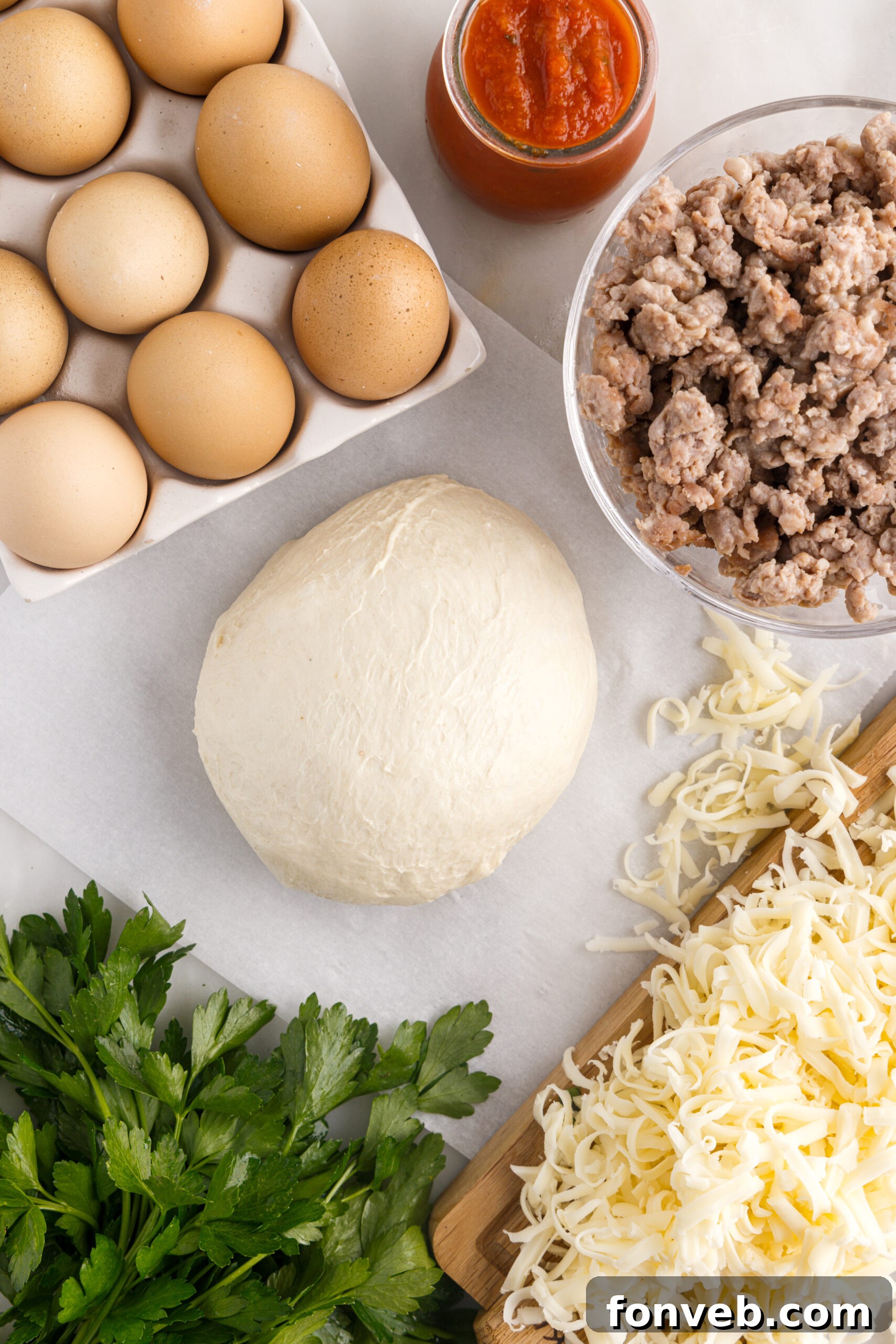 All the fresh ingredients required for preparing a mouthwatering Breakfast Pizza, laid out neatly on a clean kitchen counter.