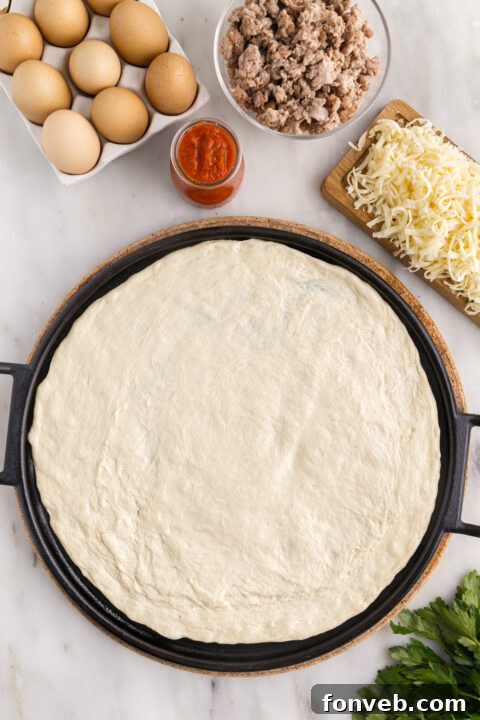 Overhead view of a perfectly baked Breakfast Pizza with runny eggs, ready to be sliced.