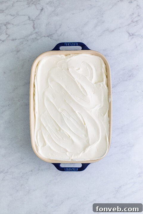The fully assembled Banana Icebox Cake, tightly covered with plastic wrap and ready to be placed in the refrigerator for its essential chilling period.