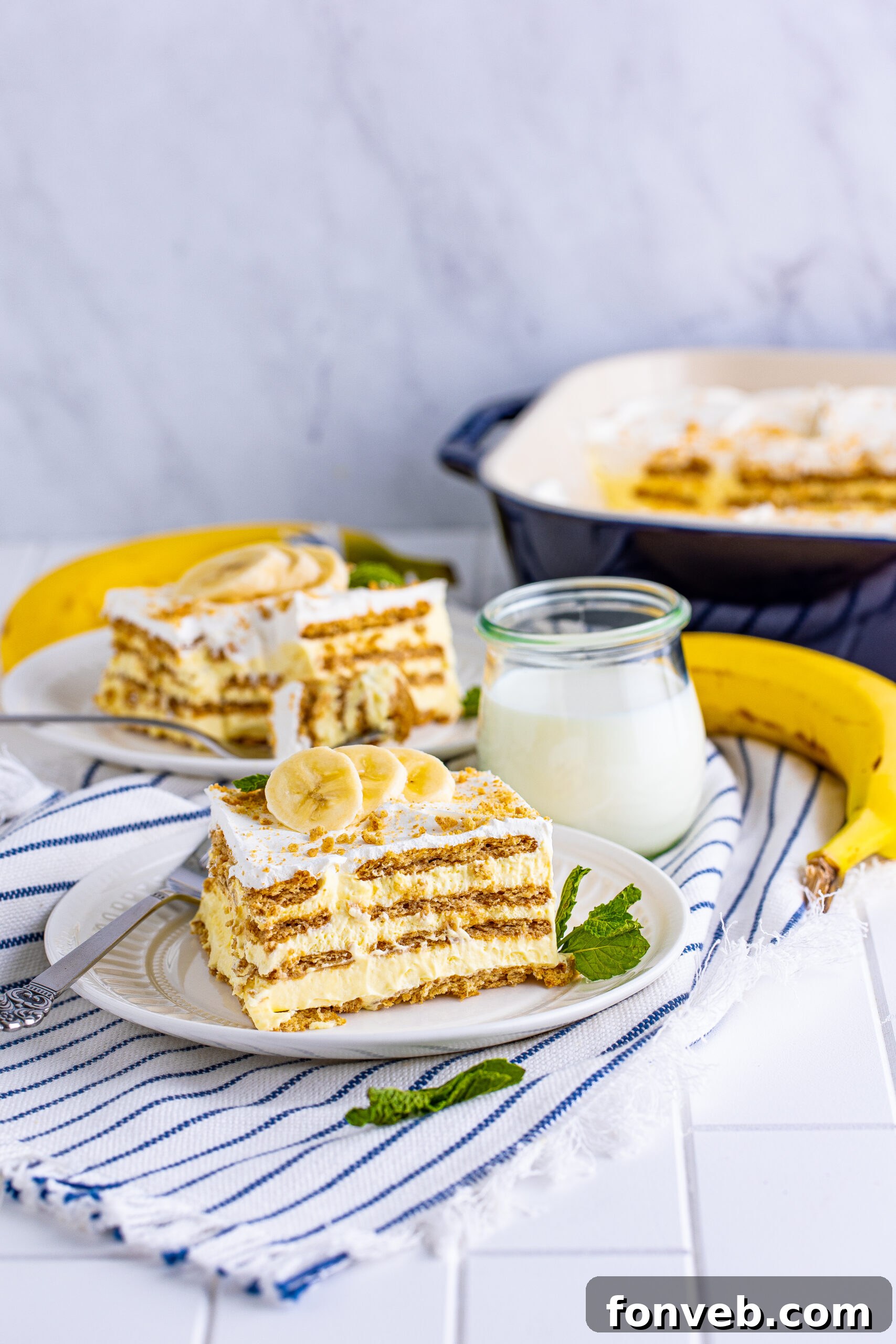 A close-up of a single, enticing slice of Banana Icebox Cake on a pristine white plate, prepared for serving and enjoyment.