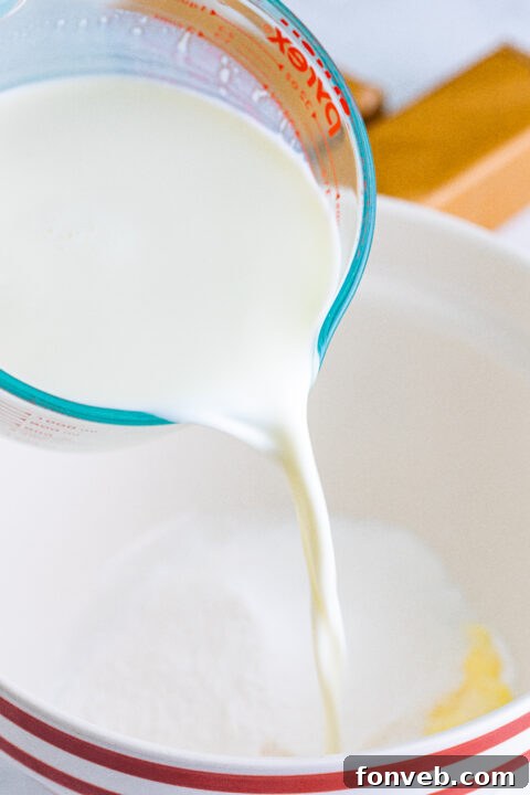 Mixing the instant banana cream pudding mix with cold milk in a large bowl, creating a smooth and creamy base for the icebox cake.