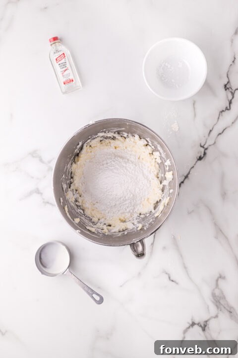 Bright red strawberry Jell-O being poured evenly over a cake layer.