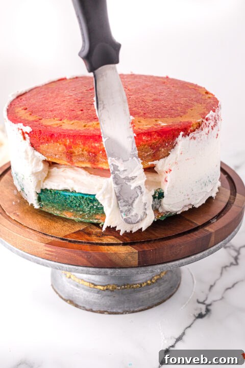 Vibrant blue berry Jell-O being poured over a second cake layer.