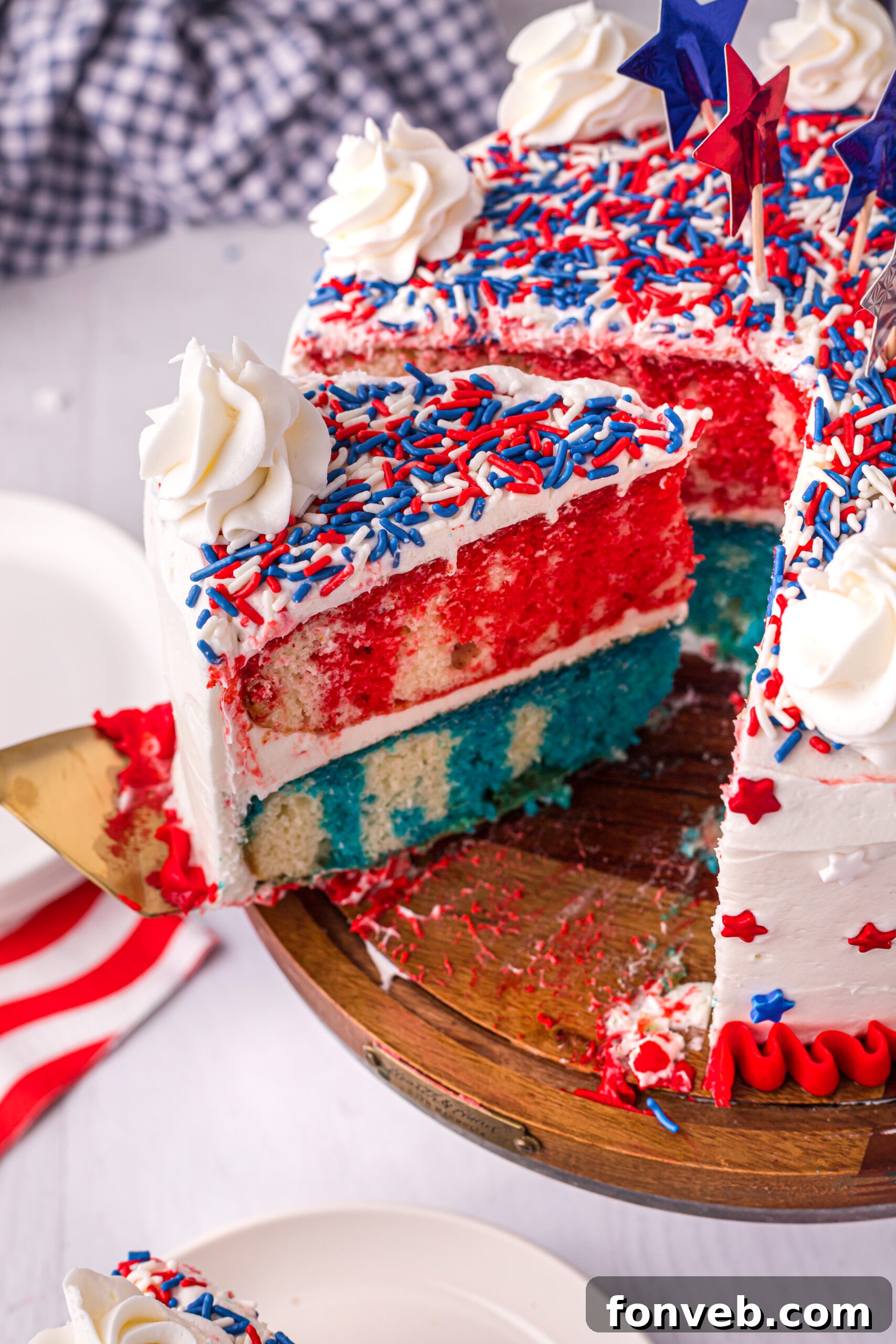 Side view of a slice being removed from the 4th of July Cake, showcasing its festive, layered interior.