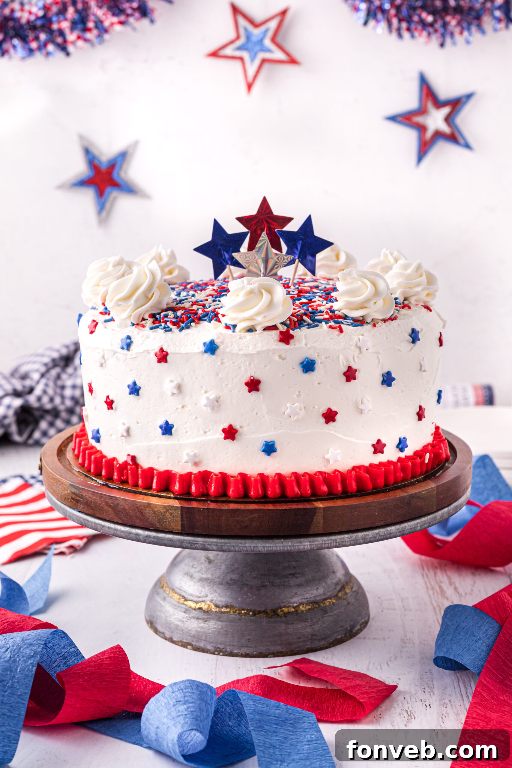 Fully decorated 4th of July Cake on a wooden cake stand, ready to be served.