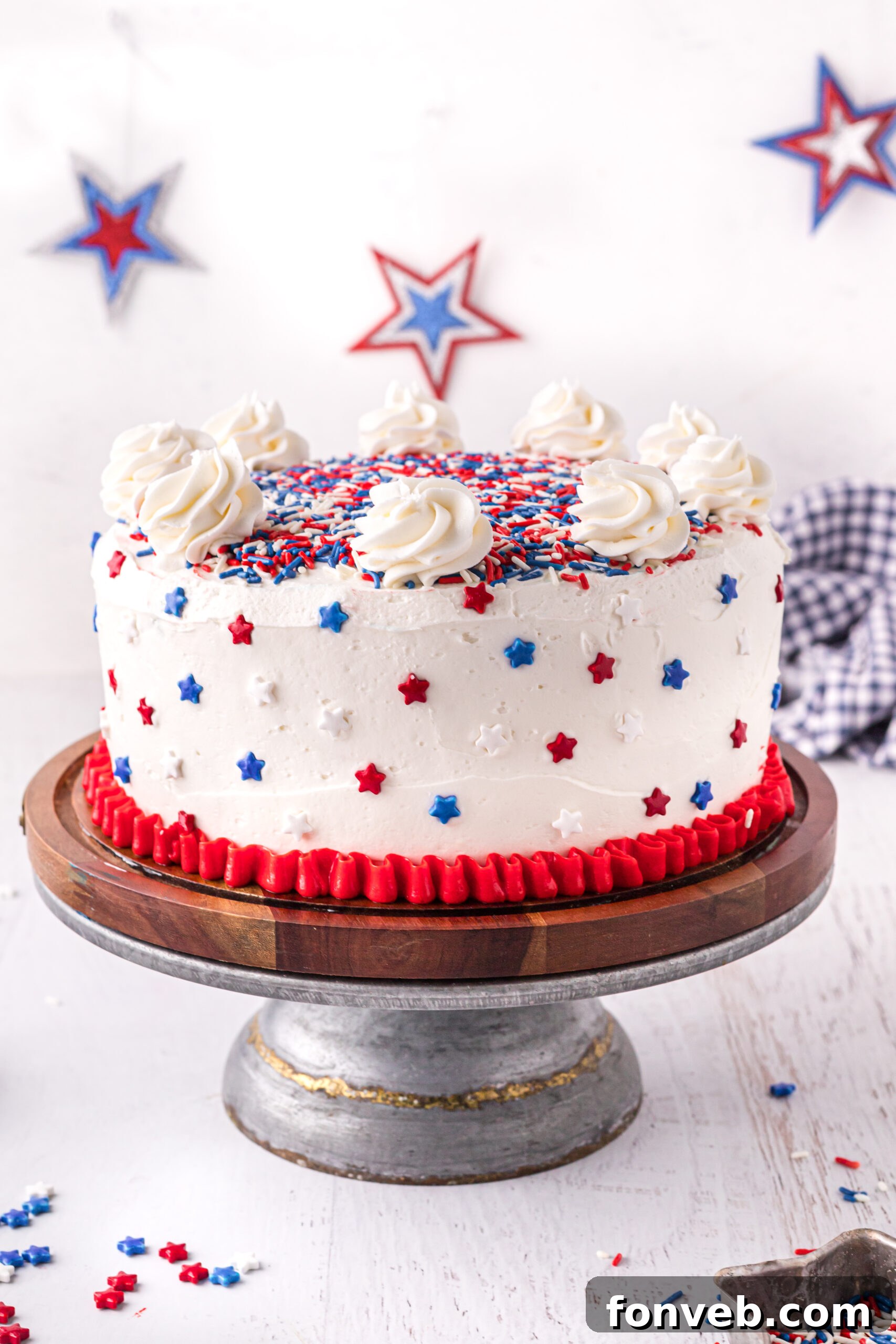 Front view of a beautifully decorated 4th of July Cake on a wooden cake stand, ready for celebration.