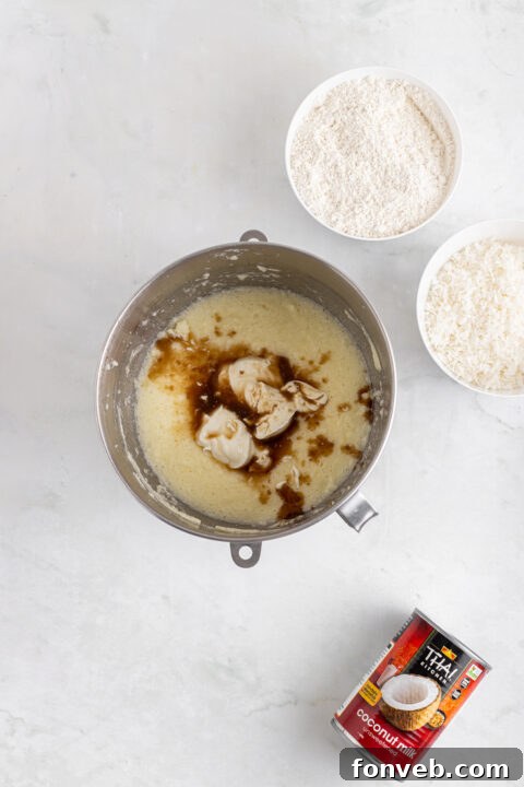 Tropical Coconut Dream Cake 11 Cake batter being poured into prepared round cake pans.