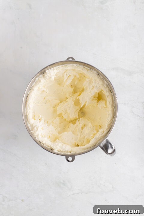 Tropical Coconut Dream Cake 14 The first layer of cake being frosted on a cake stand.