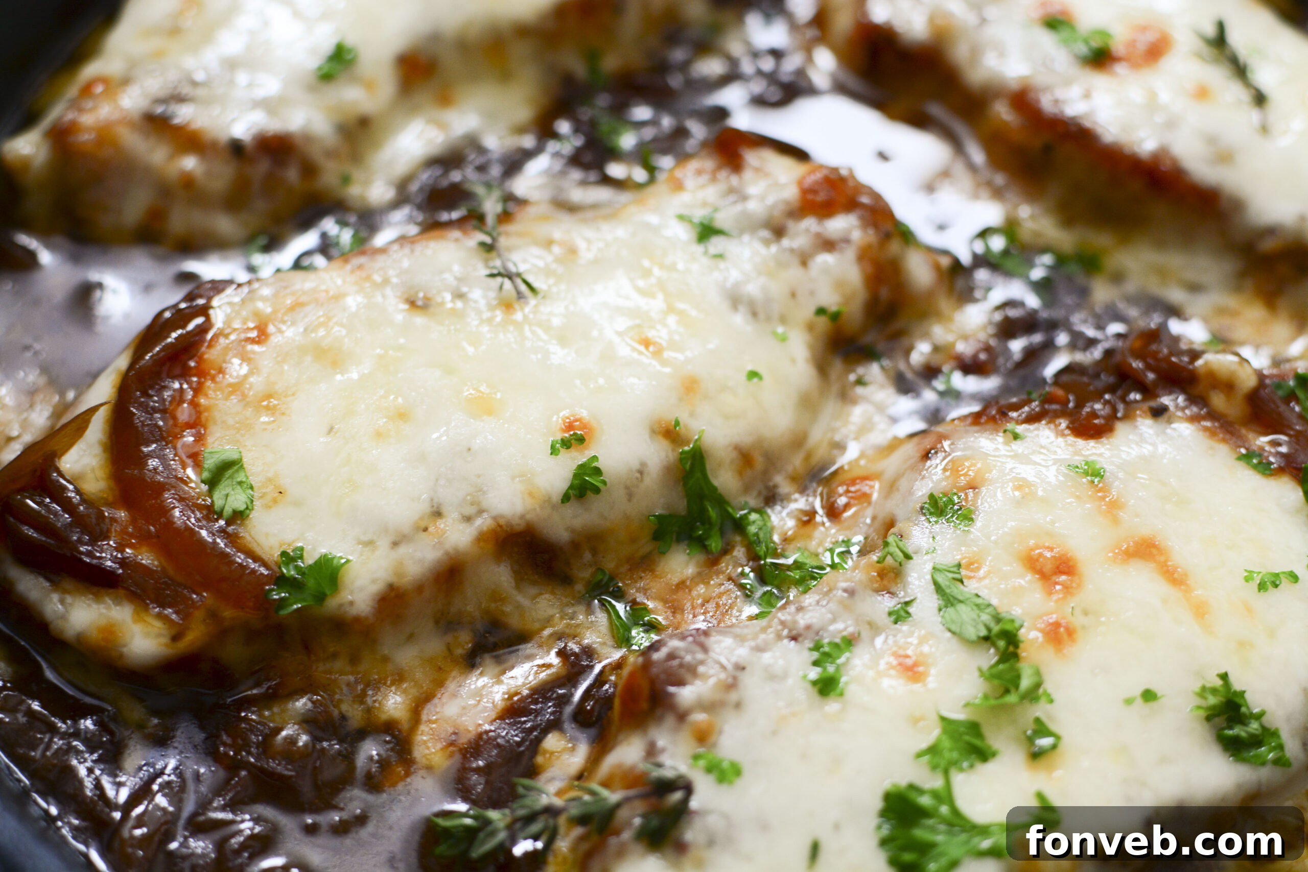 Close-up of French Onion Pork Chops in a cast iron skillet, ready to be served, showing the texture and richness.