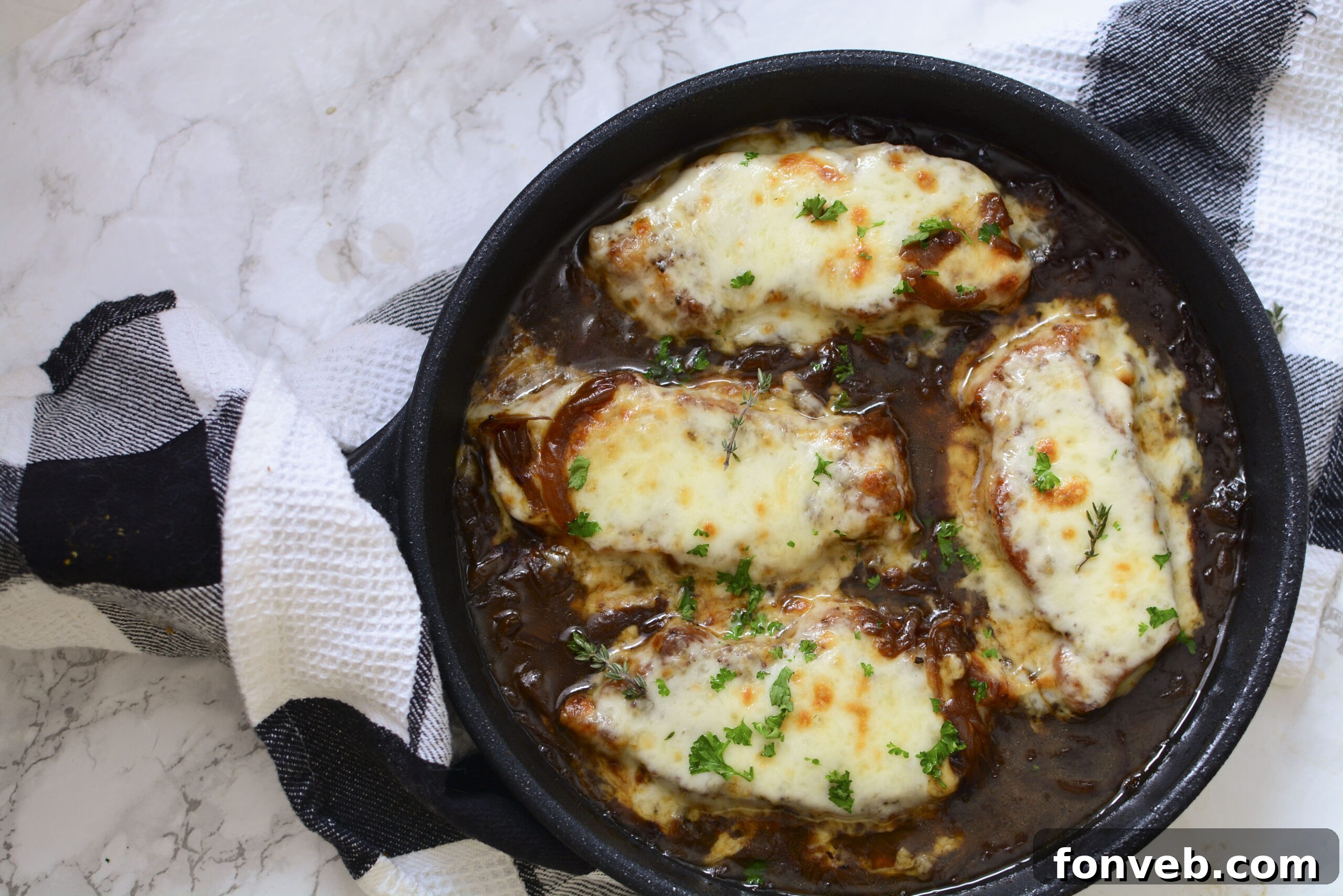 Top-down view of French Onion Pork Chops in a cast iron skillet, before being served.