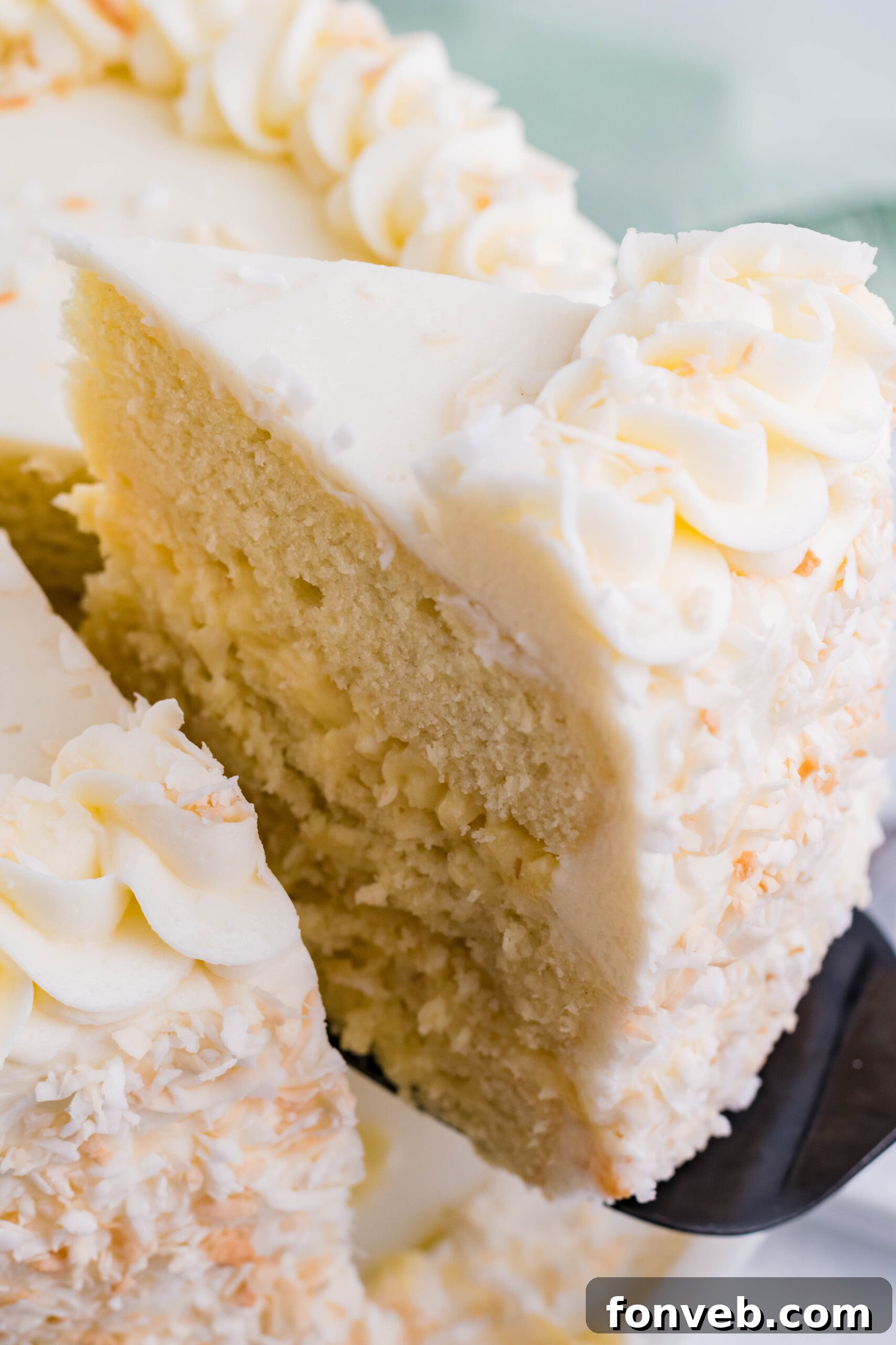 Close up view of a slice being removed from Coconut Custard Cake.