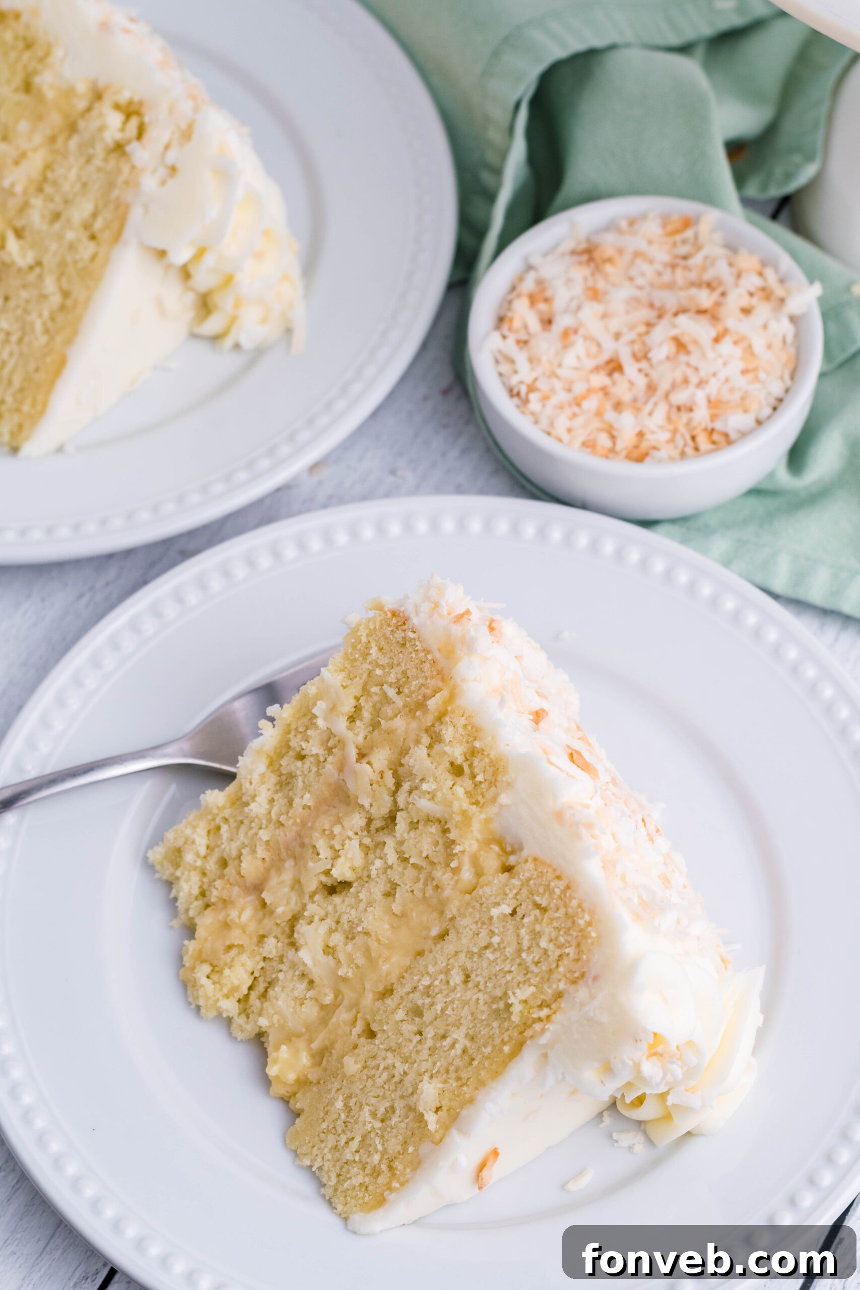Overhead view of a slice of Coconut Custard Cake on a white plate.