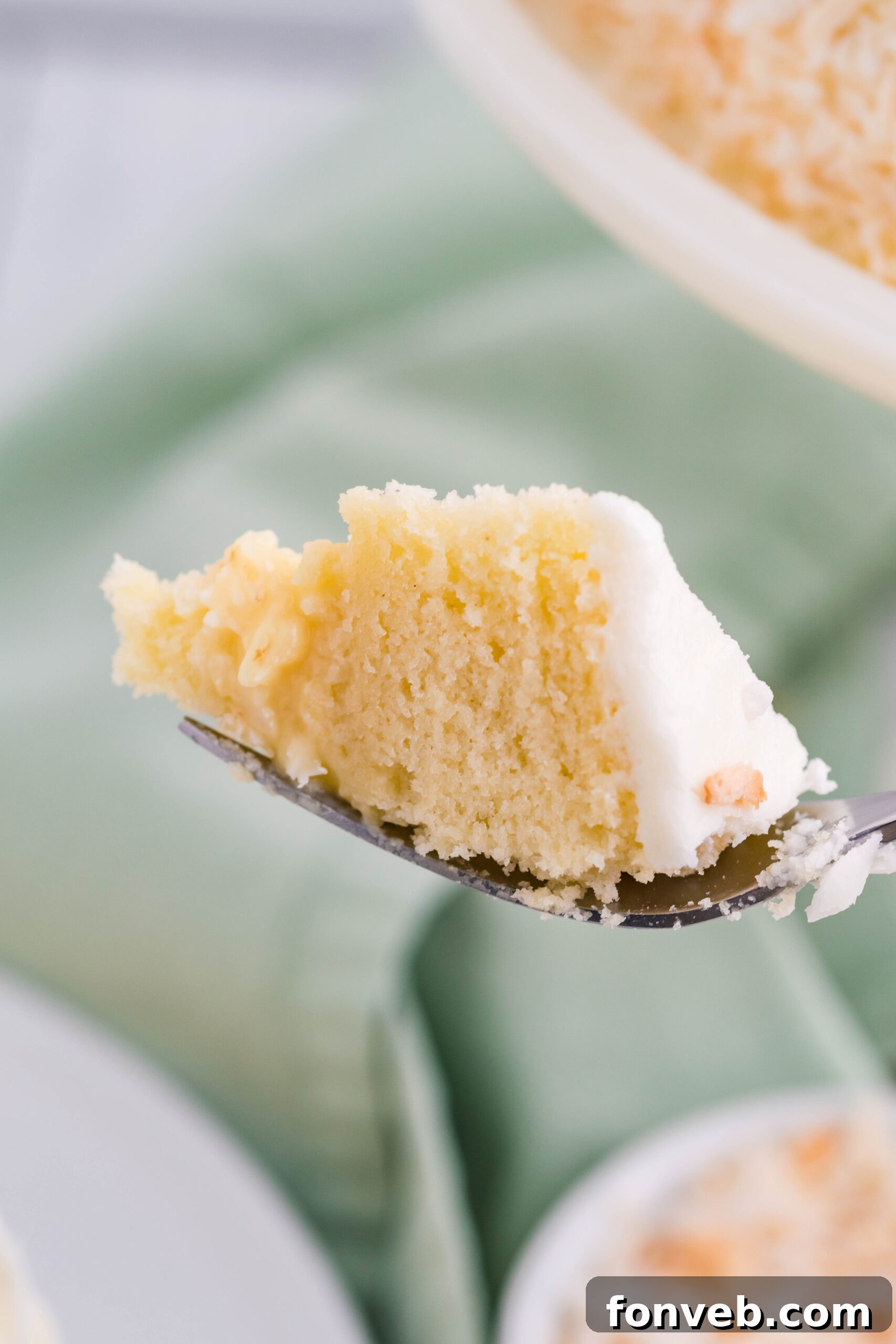 Front view of a bite of Coconut Custard Cake on a silver fork.
