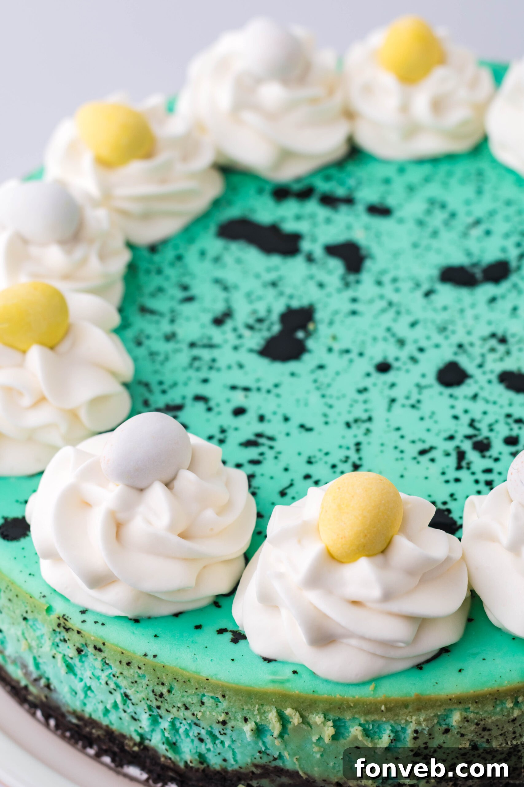 Close up view of Speckled Egg Easter Cheesecake on a white cake stand, showing off the intricate speckle detail.