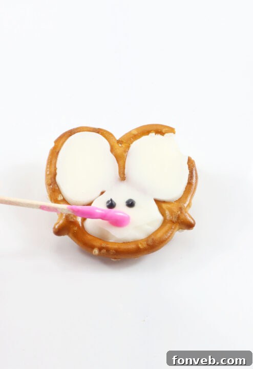 Hoppy Twists 6 The process of adding black dots for eyes on a pretzel, demonstrating the precision required for the bunny's face.