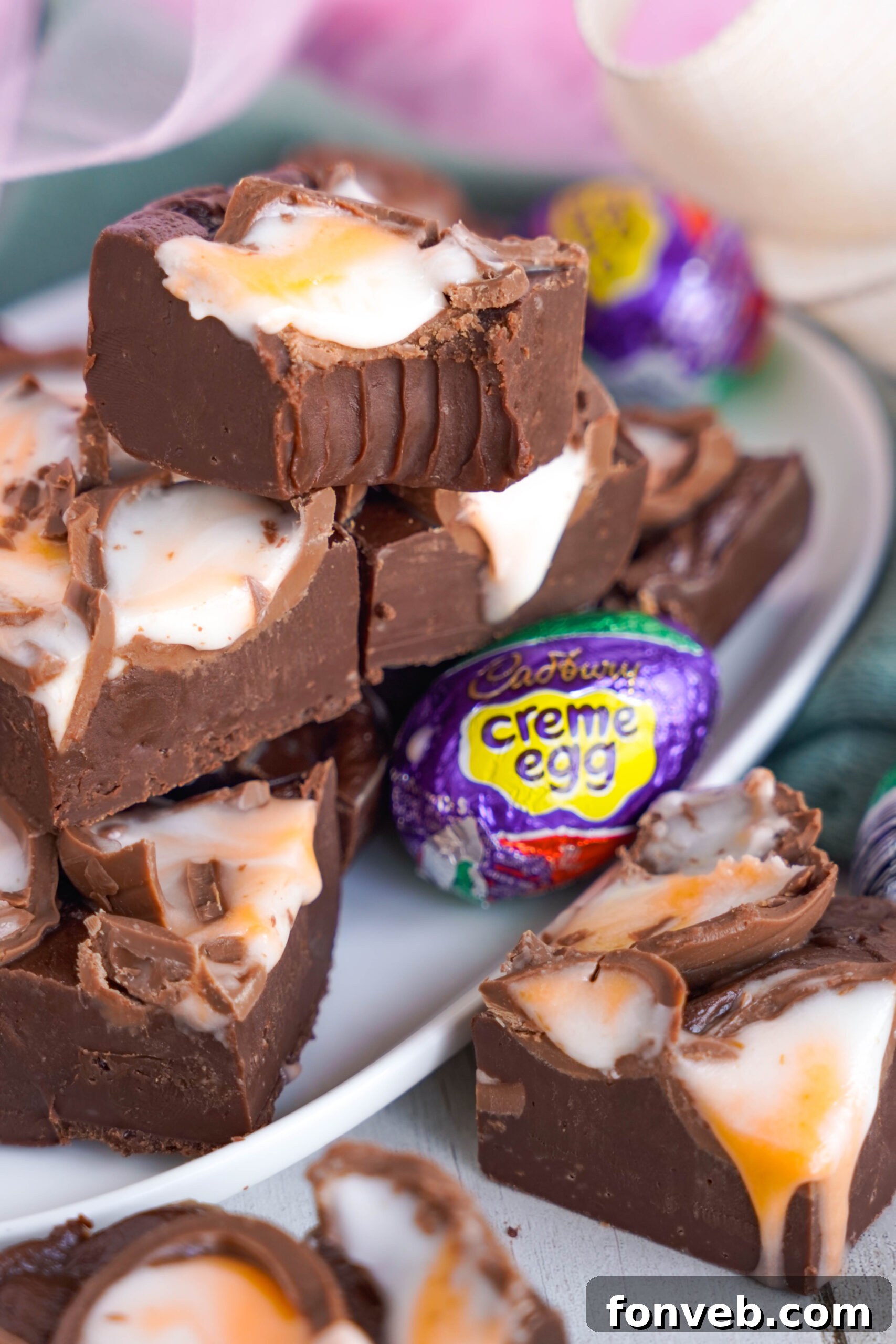 Front view of a stack of Cadbury Cream Fudge with a bite removed from the top piece.