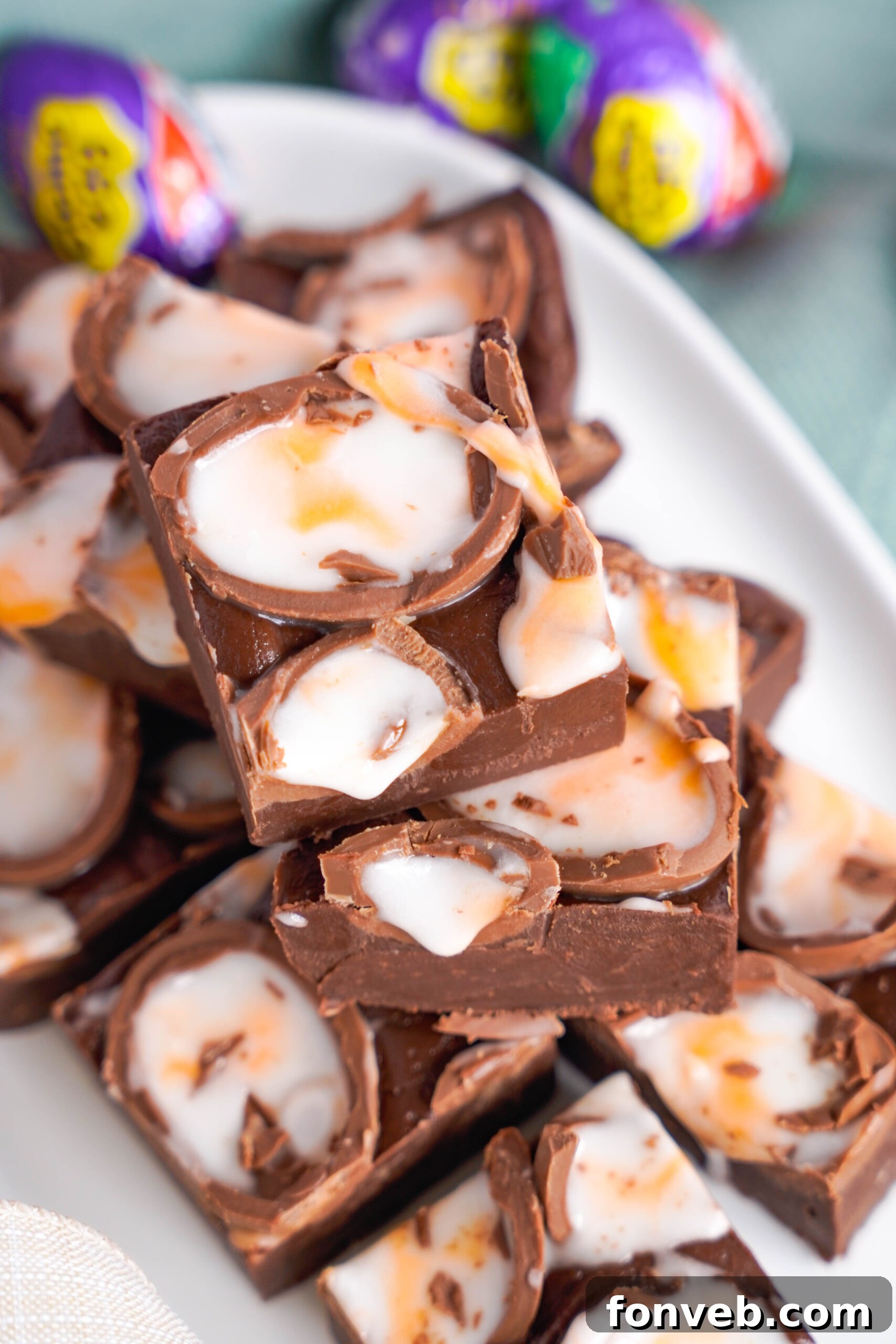 Overhead view of Cadbury Cream Fudge stacked on a white dish.