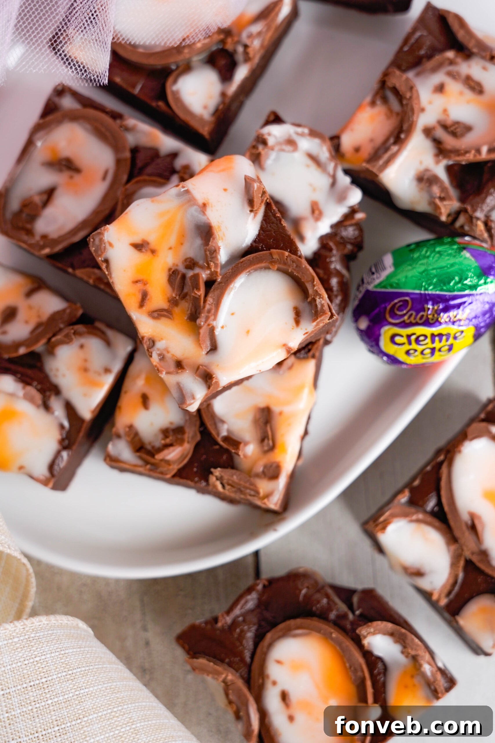 Overhead view of Cadbury Cream Fudge stacked on a white dish.