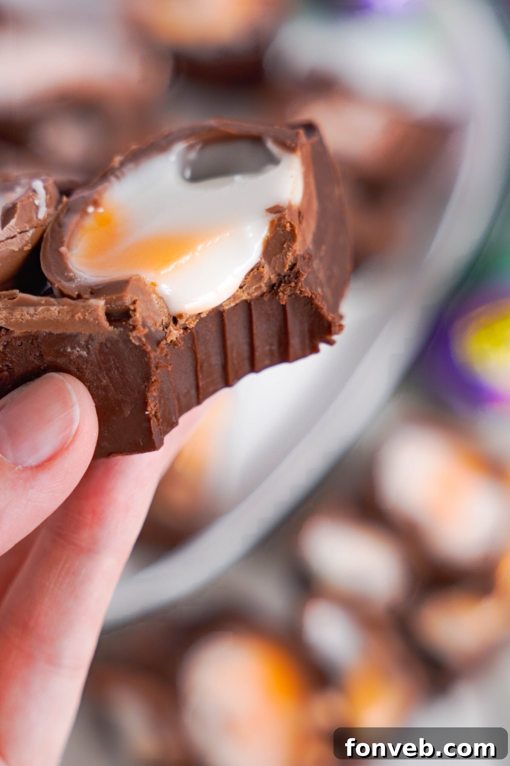 Close up view of a piece of Cadbury Cream Fudge with a bite removed.