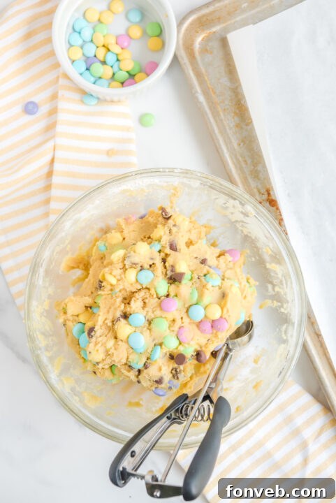 A close-up of a single Easter Pudding Cookie with visible chocolate and M&Ms.