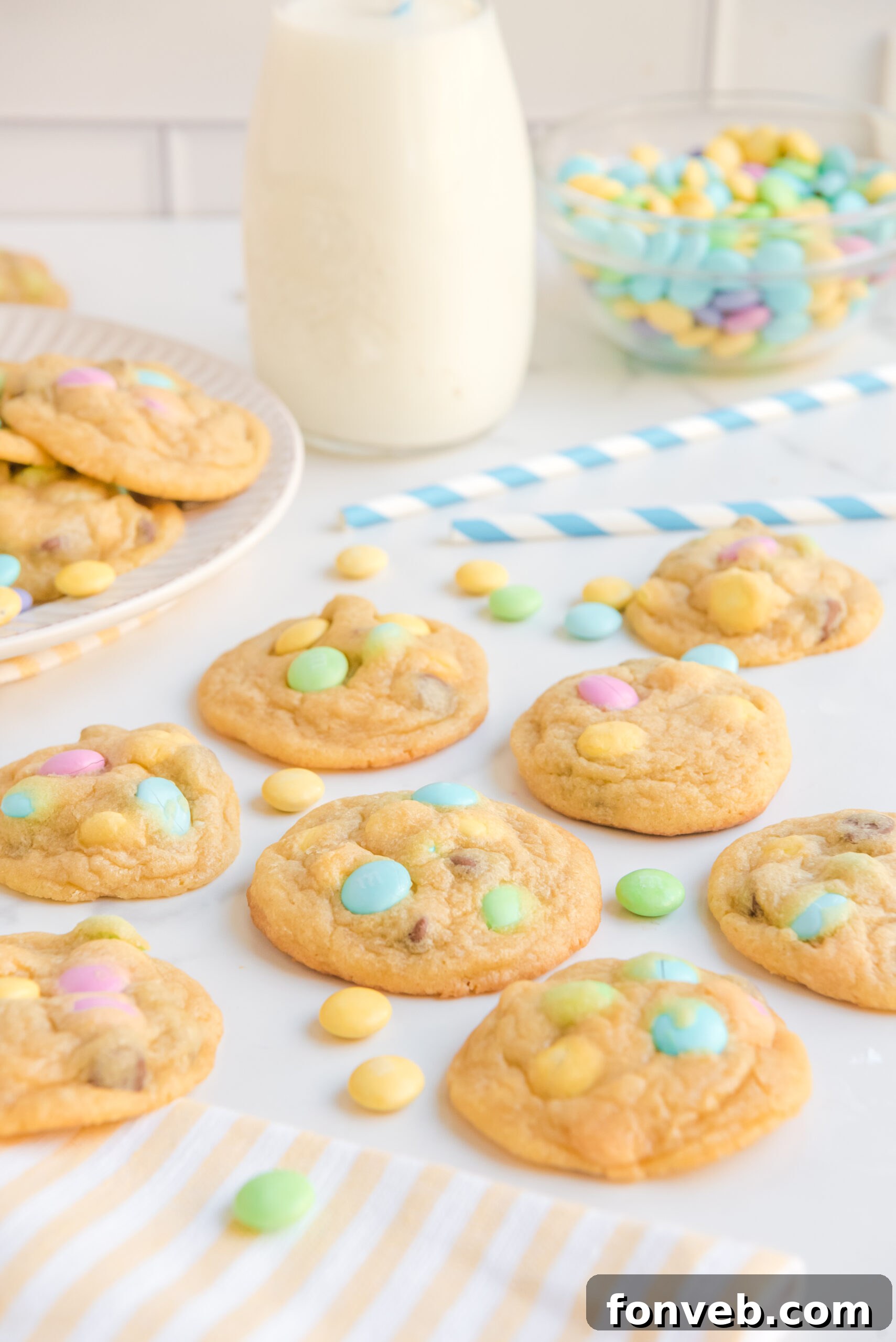 Front view of a large batch of Easter Pudding Cookies spread out on a white surface.