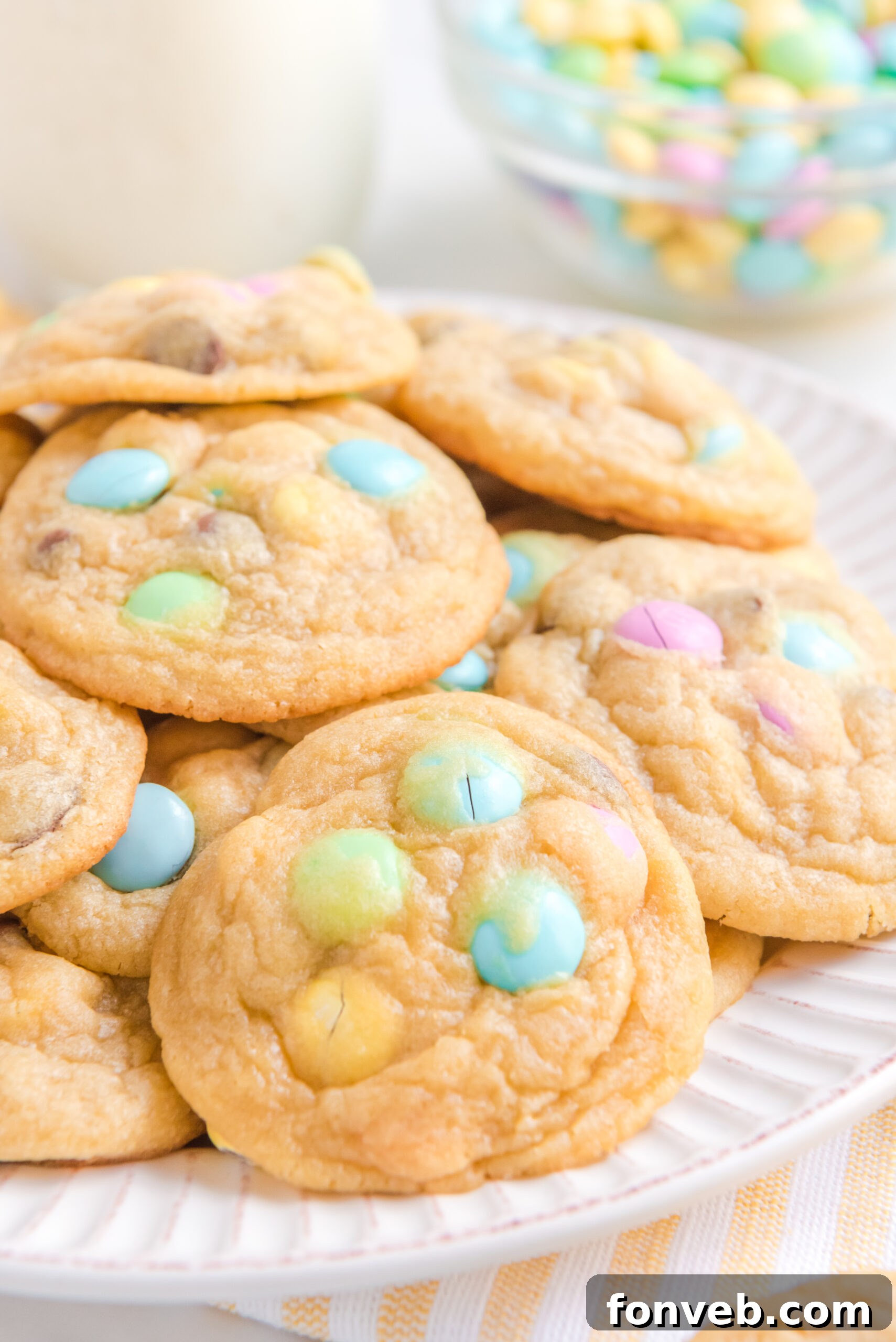 Close up view of a stack of Easter Pudding Cookies on a white plate, highlighting their vibrant colors.