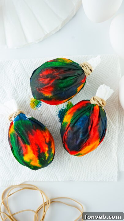 Unwrapping a tie-dye Easter egg.