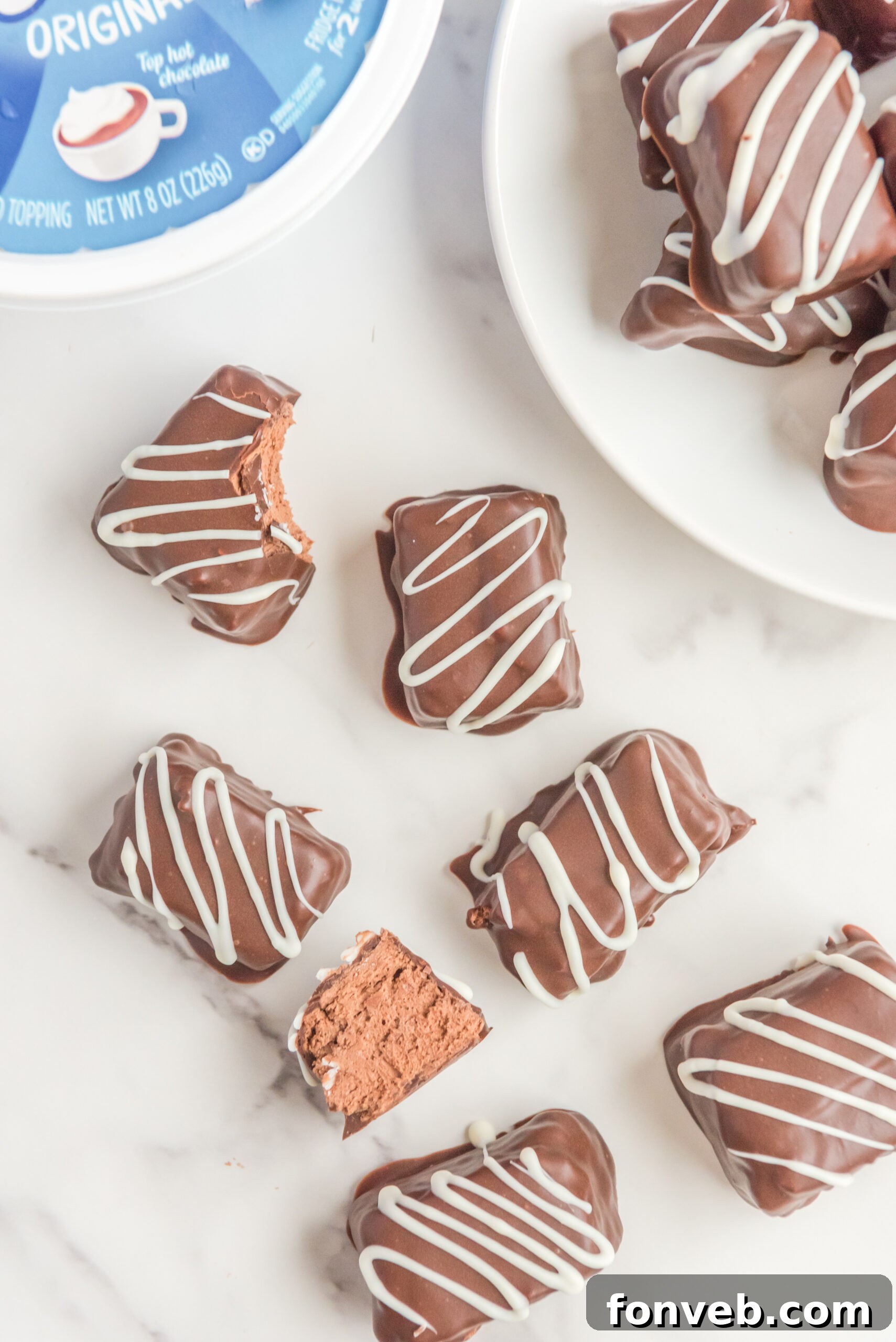 Sweet Cloud Candies 10 An overhead view of two Cool Whip Candy bars, both with bites taken, artfully arranged on a white plate, highlighting their enticing inner texture.