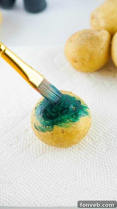 Step-by-step image showing a potato partially dyed with vibrant food coloring.