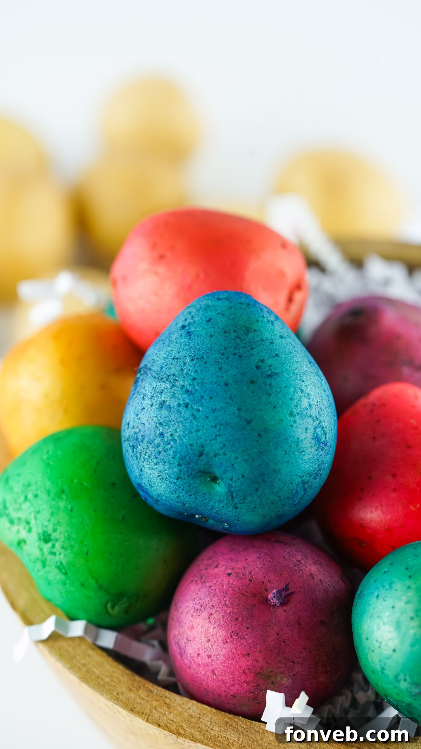 Close-up detailed view of the vibrant Dyed Easter Egg Potatoes in a brown bowl, highlighting their rich colors.