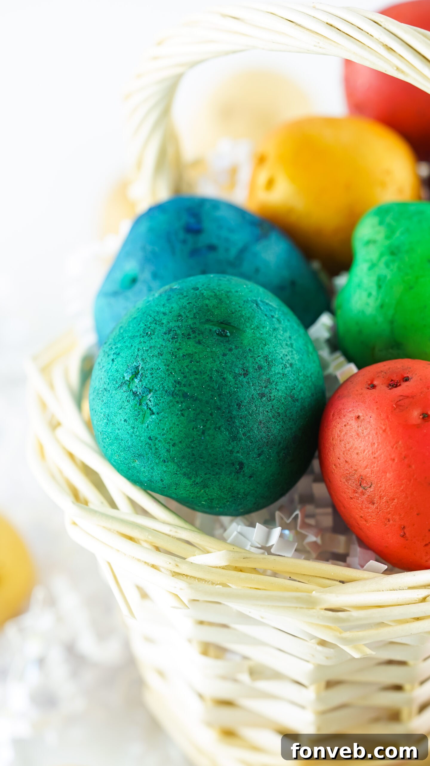 Front view of a beautiful arrangement of Dyed Easter Egg Potatoes displayed in a rustic tan basket, ready for Easter decor.