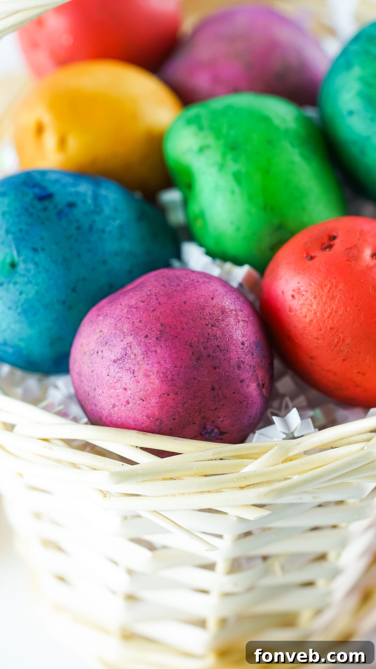 Close-up view of the finished Dyed Easter Egg Potatoes neatly arranged in a tan basket, showing their decorative appeal.