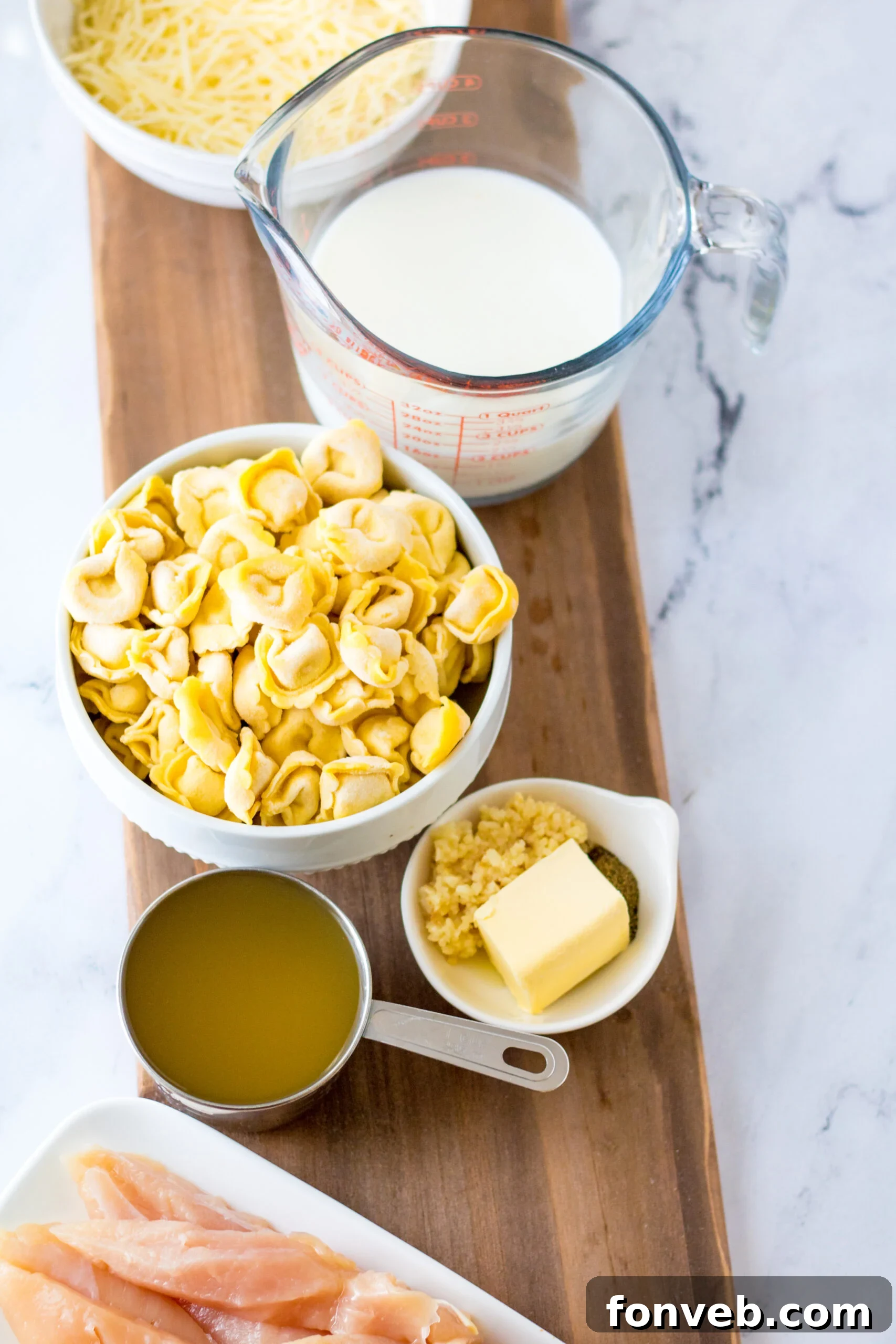 Overhead view of all fresh ingredients for Slow Cooker Chicken Tortellini laid out.