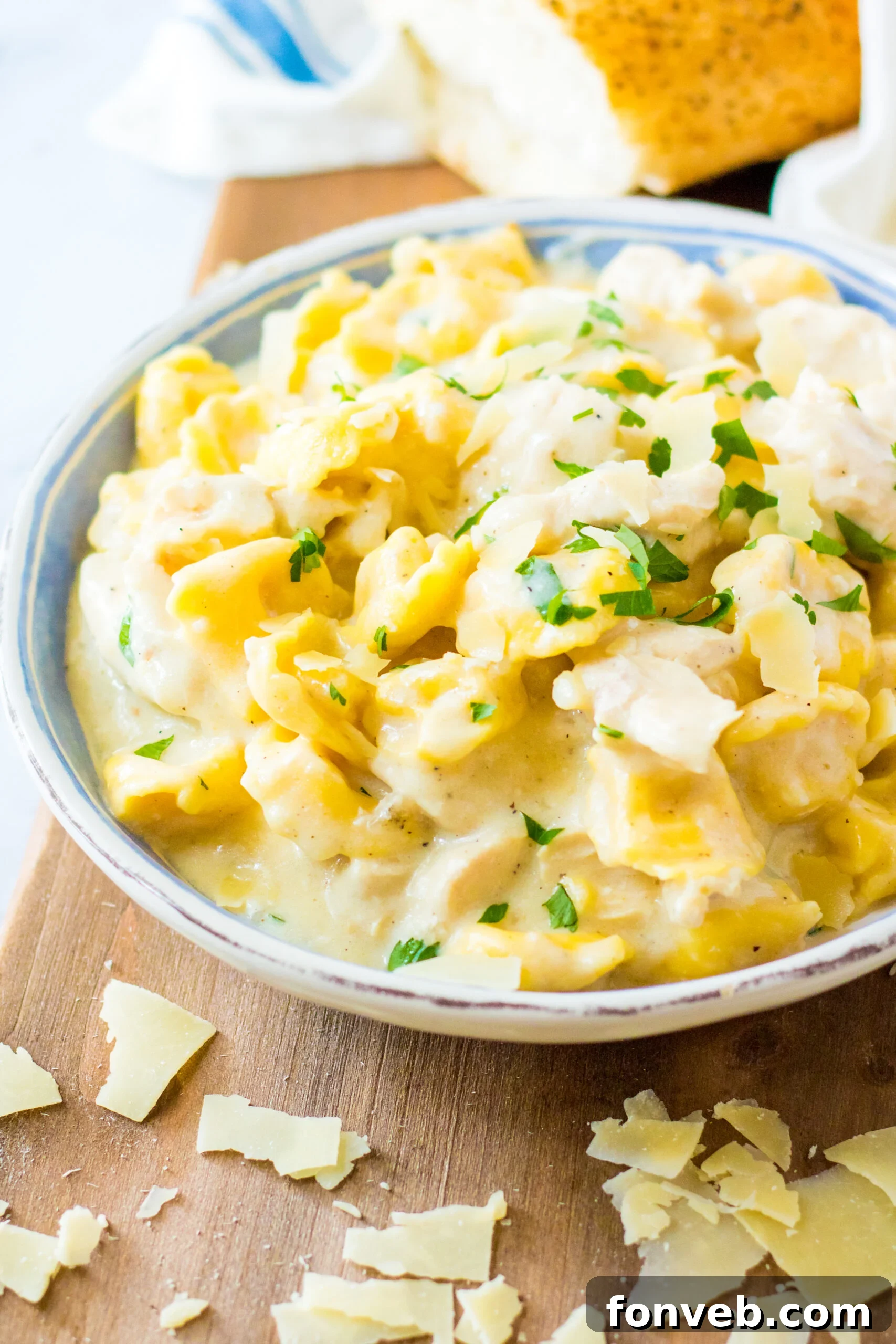 Front view of Slow Cooker Chicken Tortellini served in a white and blue bowl.
