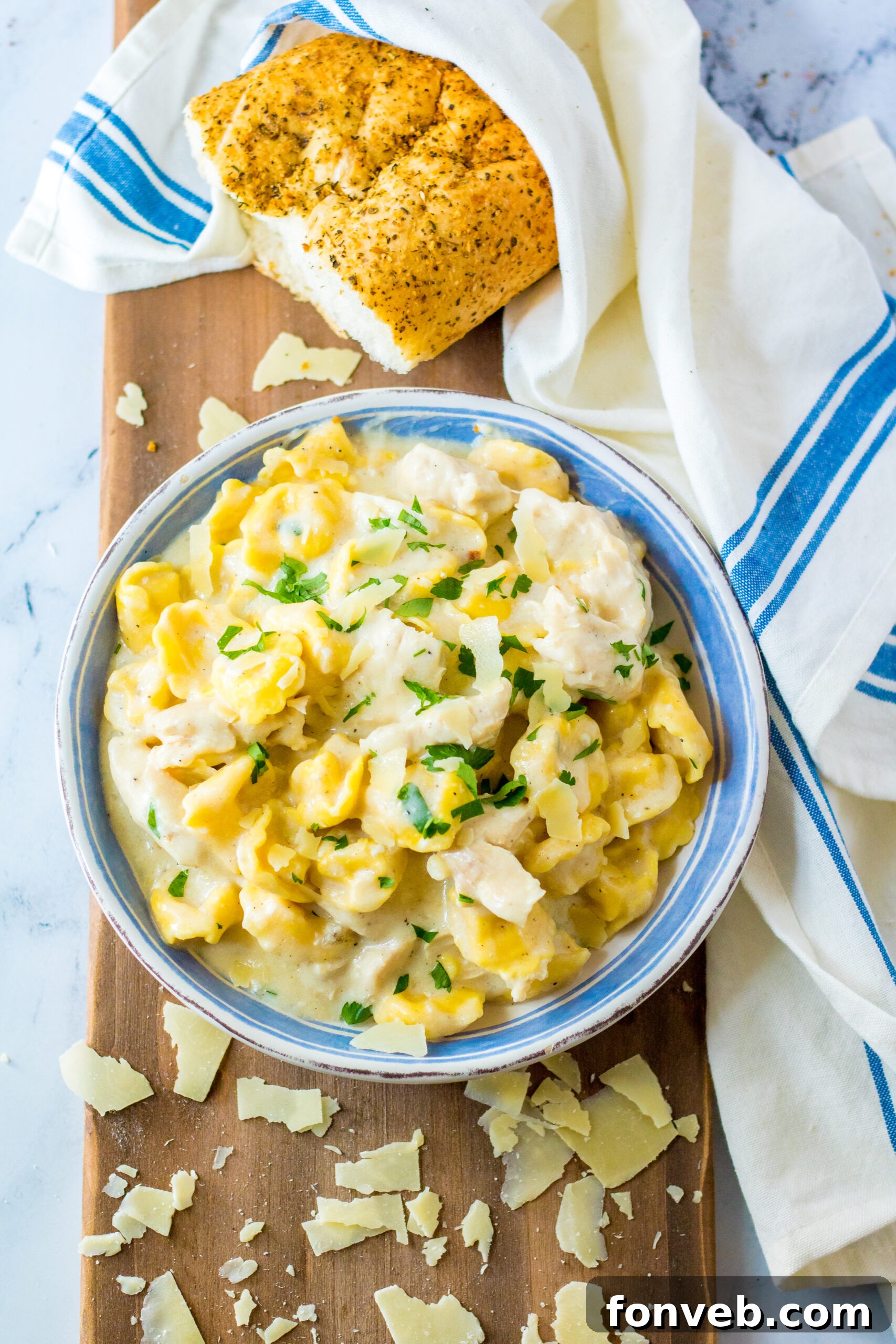 Overhead view of Slow Cooker Chicken Tortellini in a white and blue bowl, ready to serve.