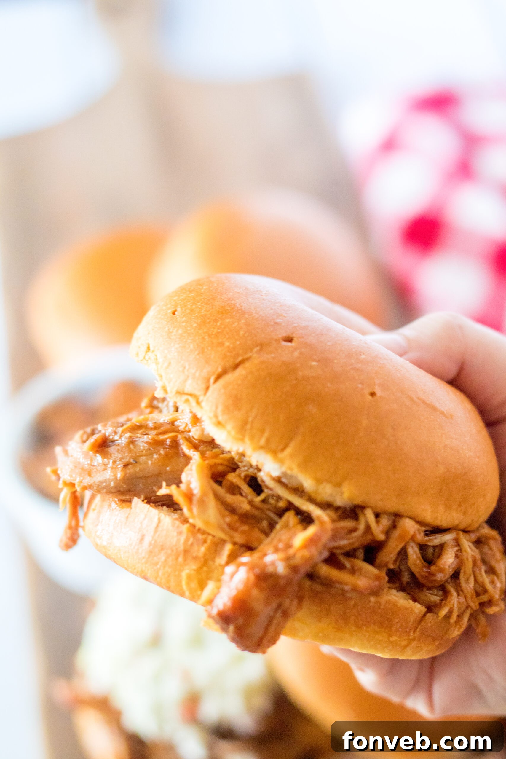 Sticky Sweet Slow Cooker Coke Pulled Pork 12 Front view of a Slow Cooker Cola Pulled pork sandwich being held.
