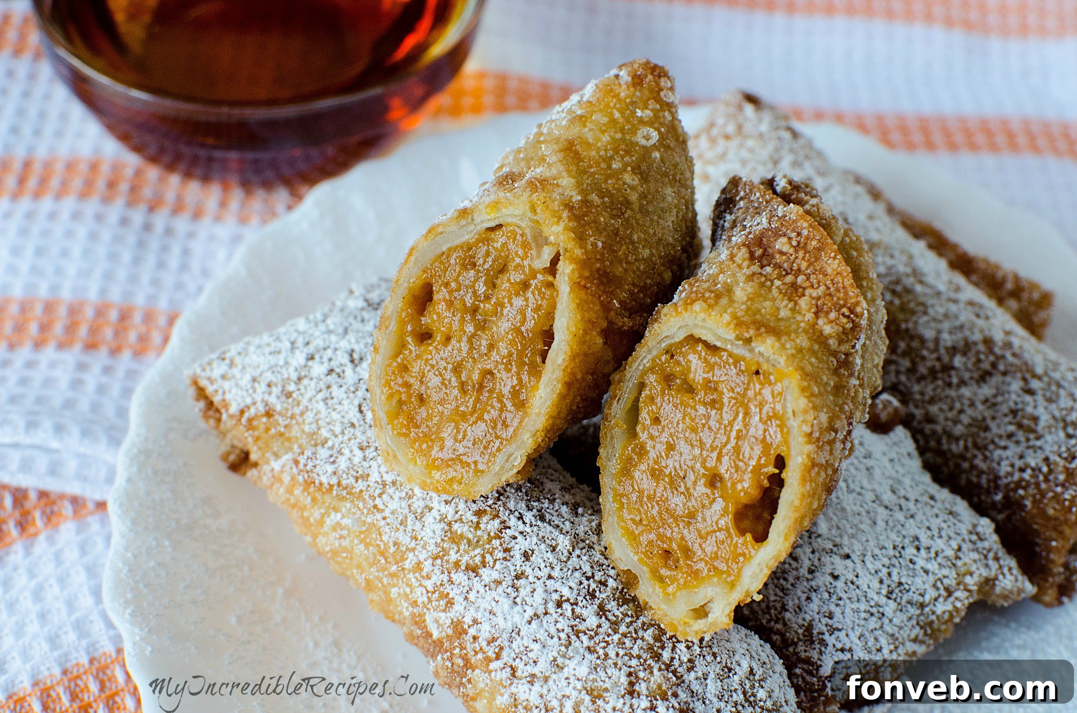 Freshly fried pumpkin egg rolls cooling on a wire rack after being removed from oil