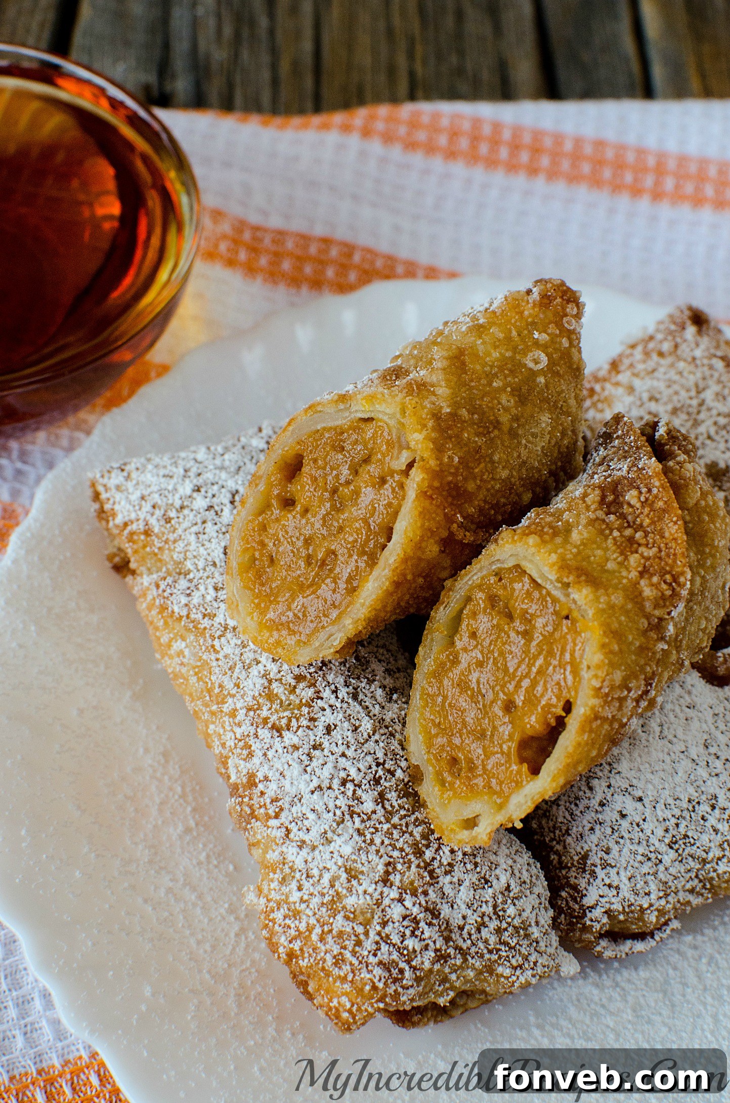 A tall stack of perfectly fried pumpkin egg rolls, showcasing their golden crust