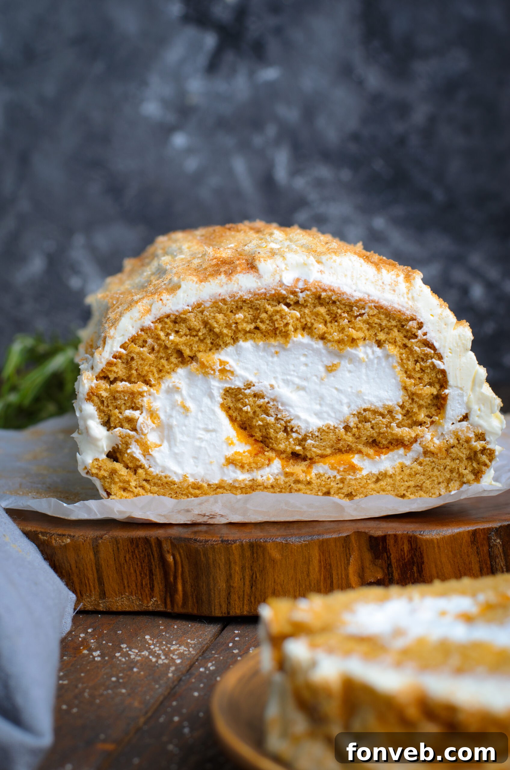 Front view of GIngerbread Cake Roll on a wooden slab.